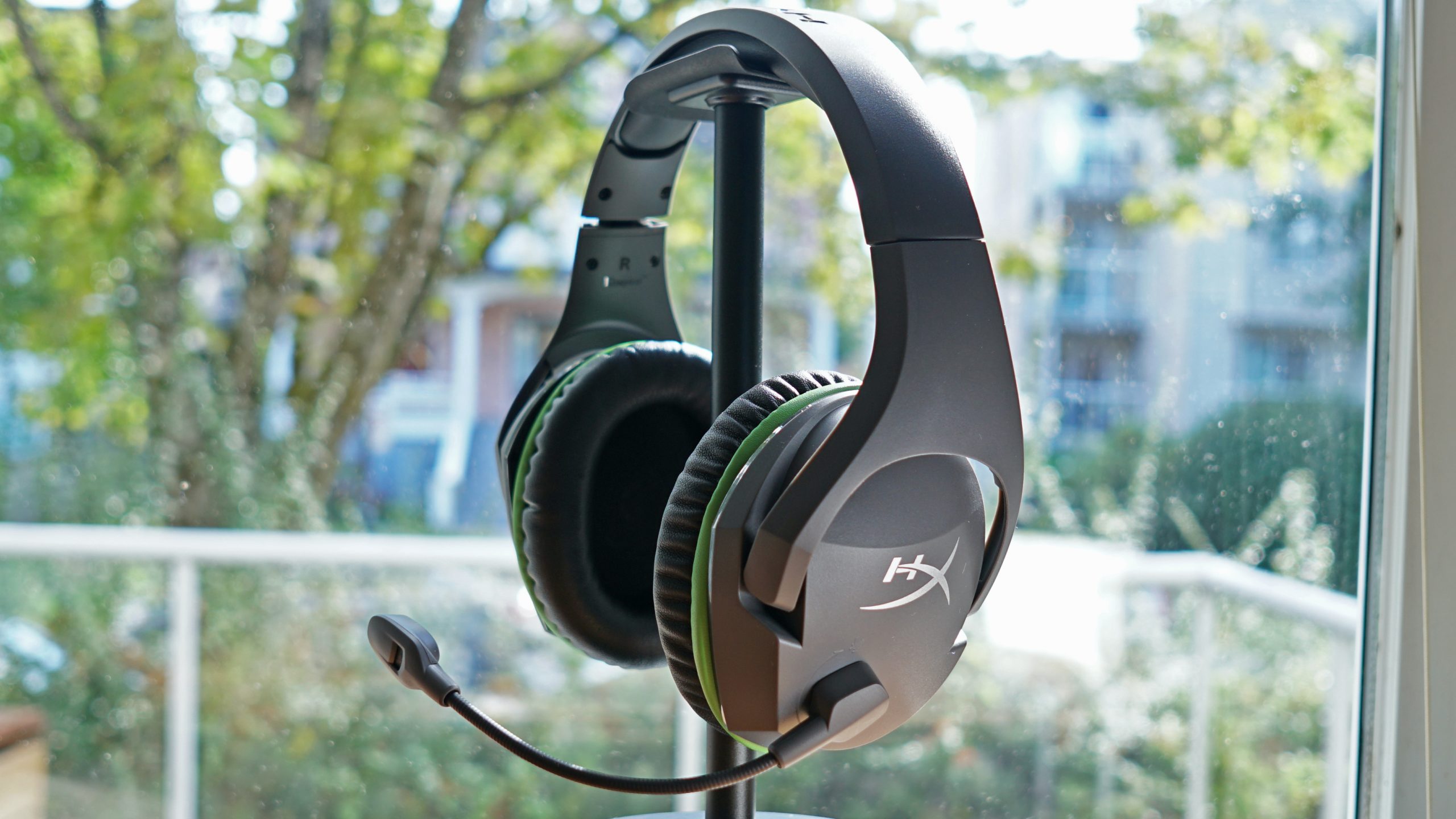 The HyperX CloudX Stinger Core sits on a headphone stand by a window