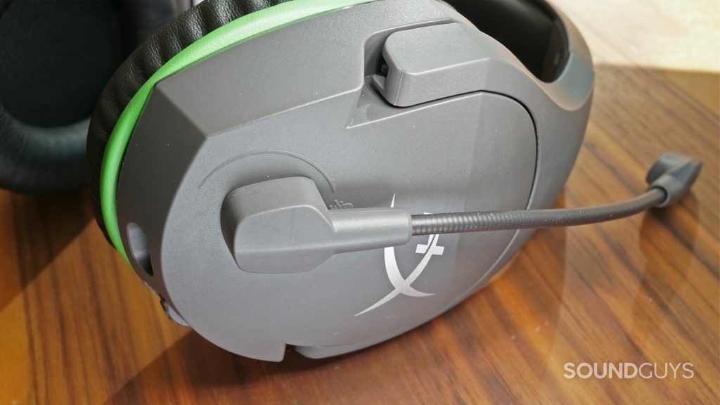The HyperX CloudX Stinger Core lays on a wooden table with its microphone flipped up.