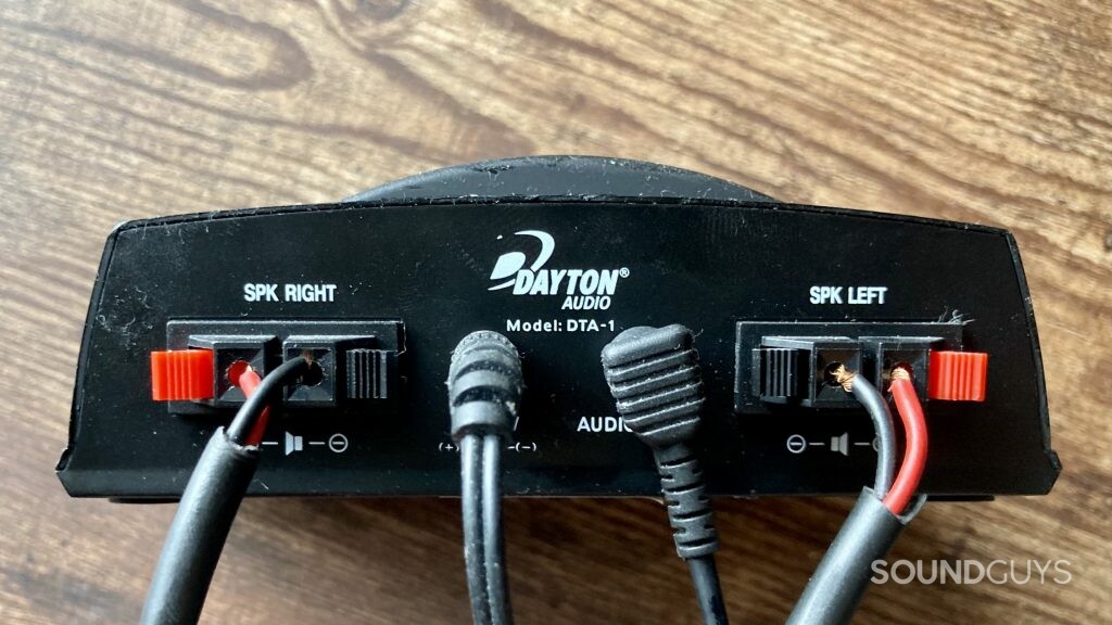 The back side of an an amplifier, showing the speaker terminals, power, and signal input connections.