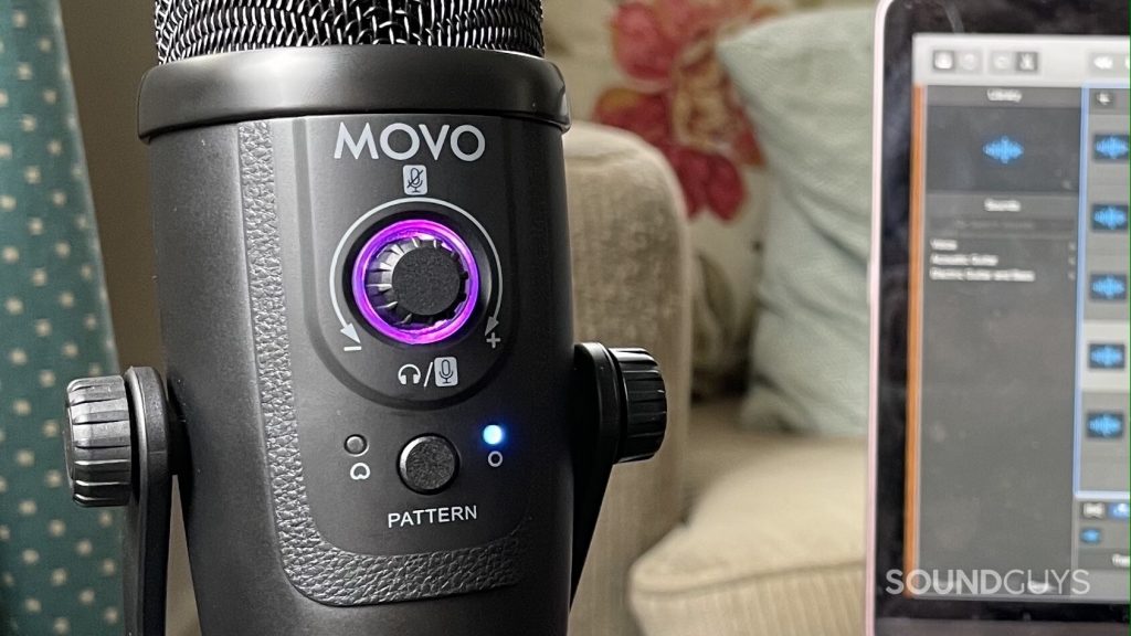 Close-up shot of the Movo UM300 control panel. A laptop with Garageband open is visible in the background.