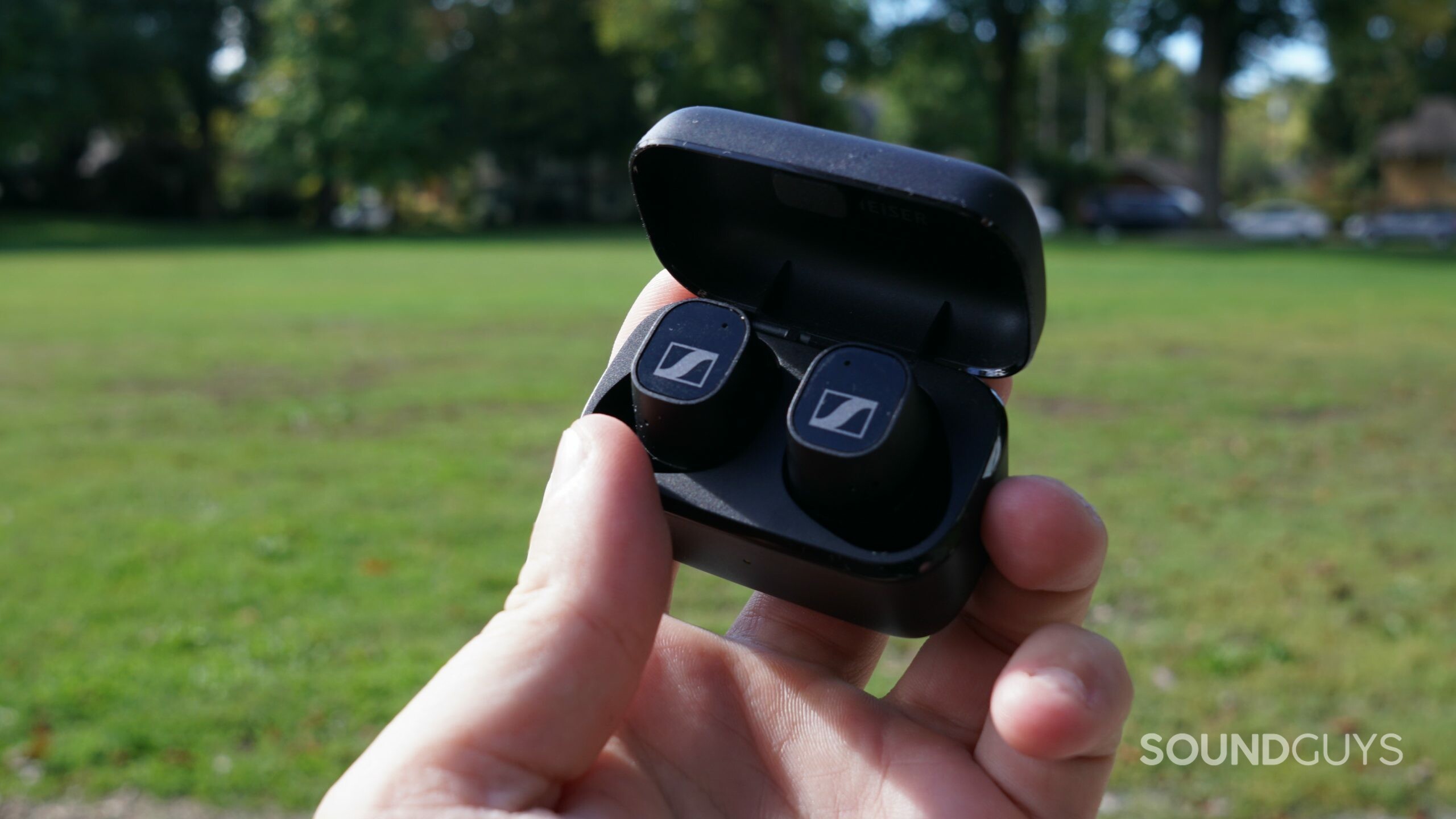 The Sennheiser CX Plus True Wireless is held outside, sitting in its case.