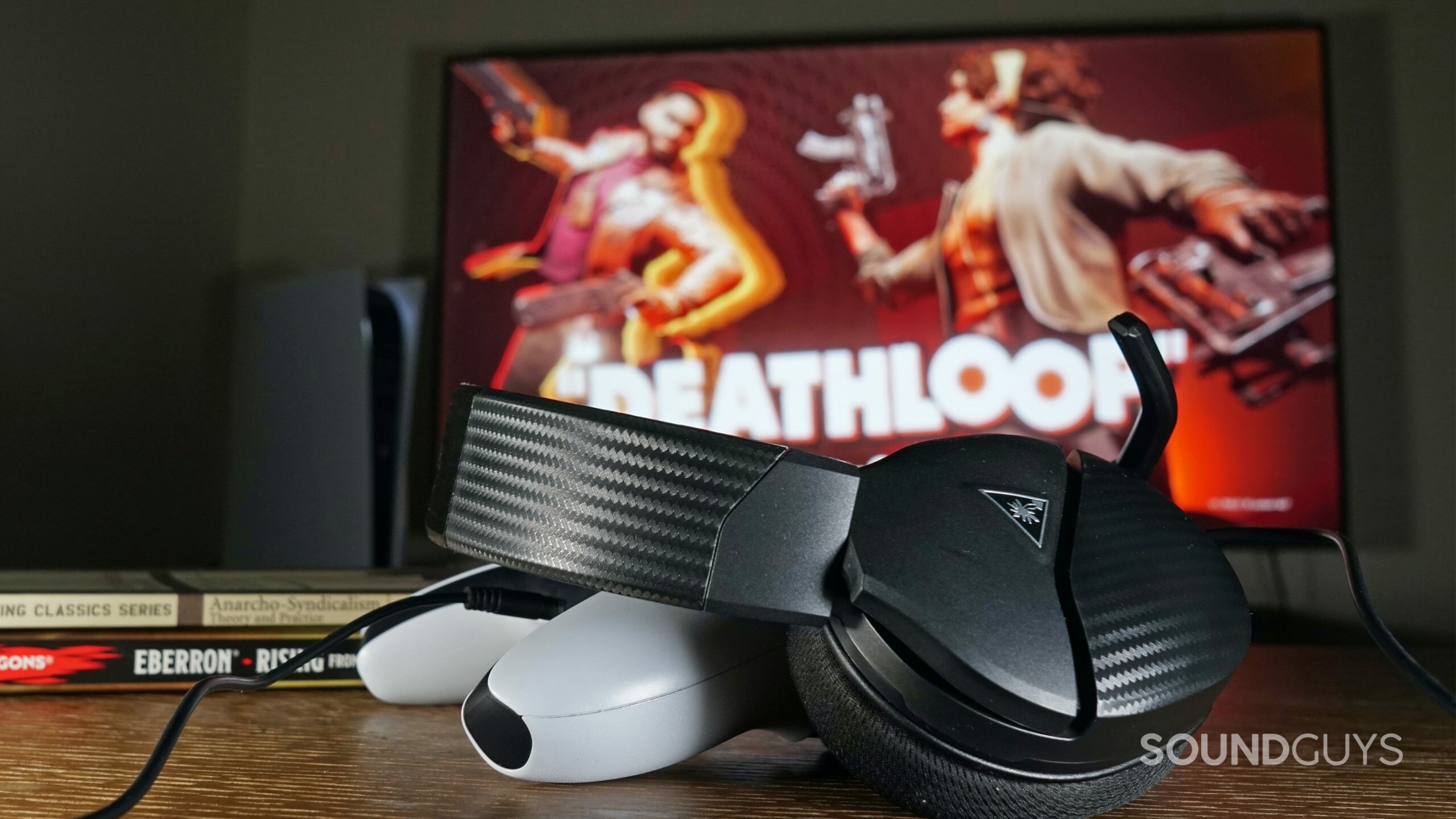 The Turtle beach Recon 200 Gen 2 gaming headset leans on a PlayStation DualSense controller in front of a TV showing Deathloop running on PlayStation 5.