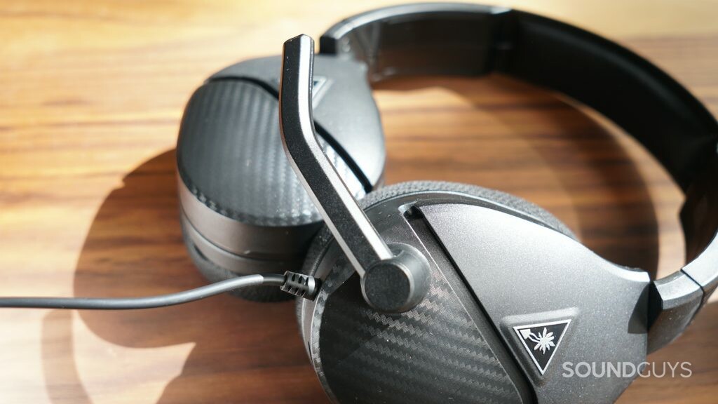 The Turtle Beach Recon 200 Gen 2 lays on a wooden table with its mic flipped down.