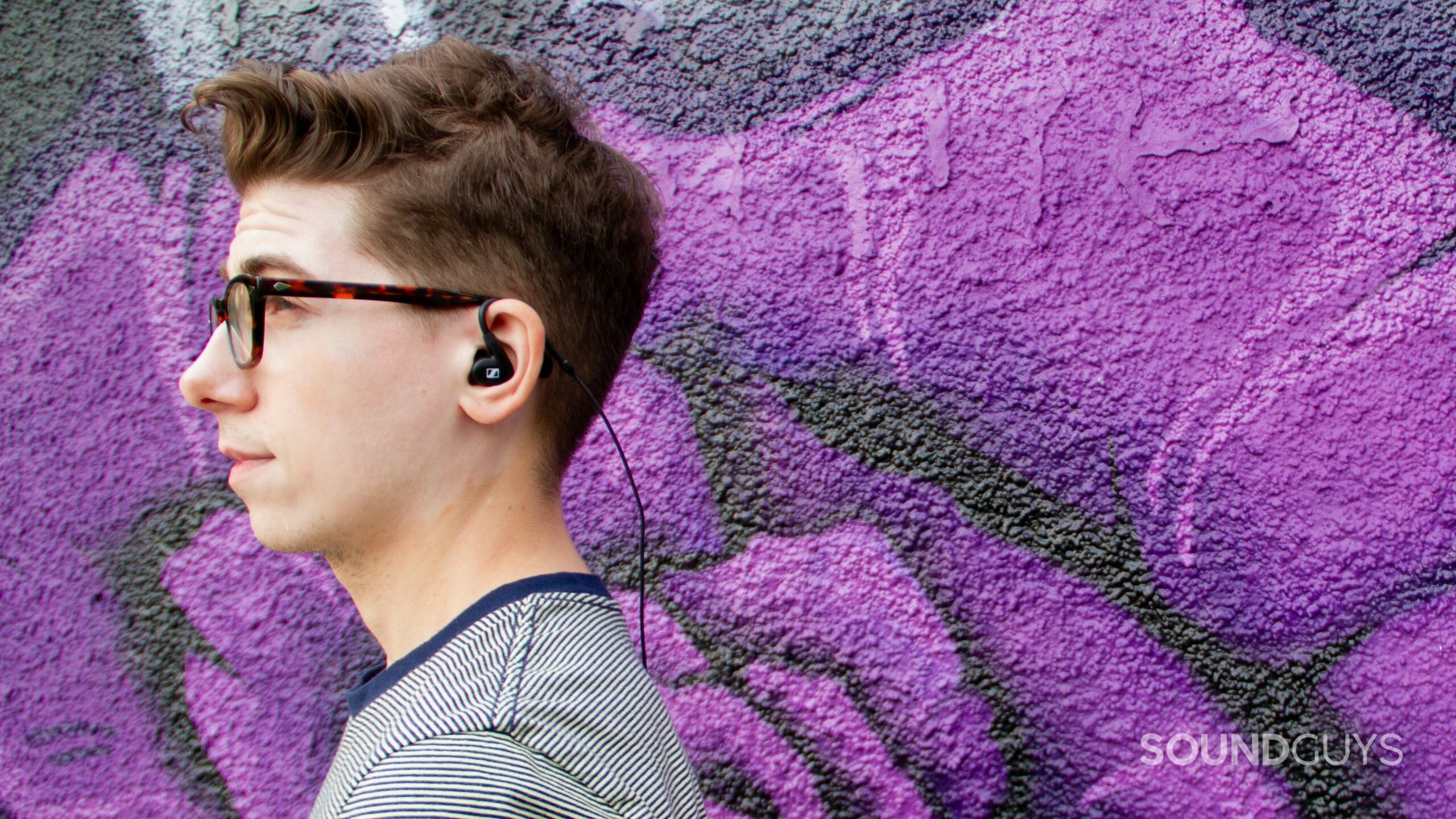 A man wearing the Sennheiser IE 100 PRO with the cable running down his back.