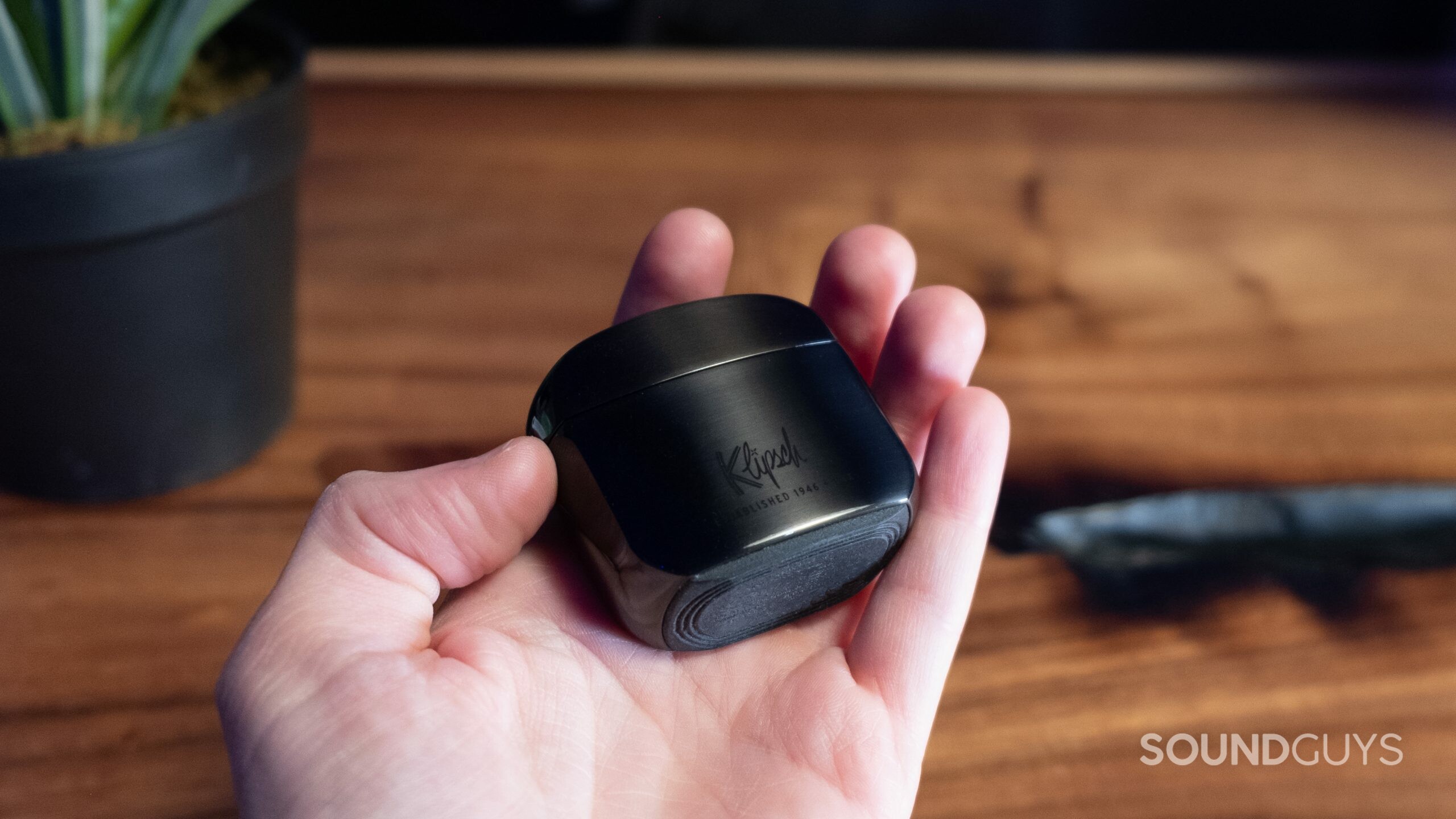 A hand holds the case showing the rubberized bottom of the Klipsch T5 II ANC.