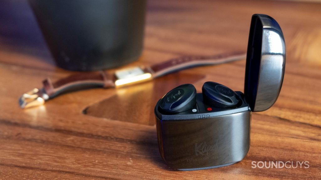 The Klipsch T5 II ANC sits on a wood table with a gold watch in the background.