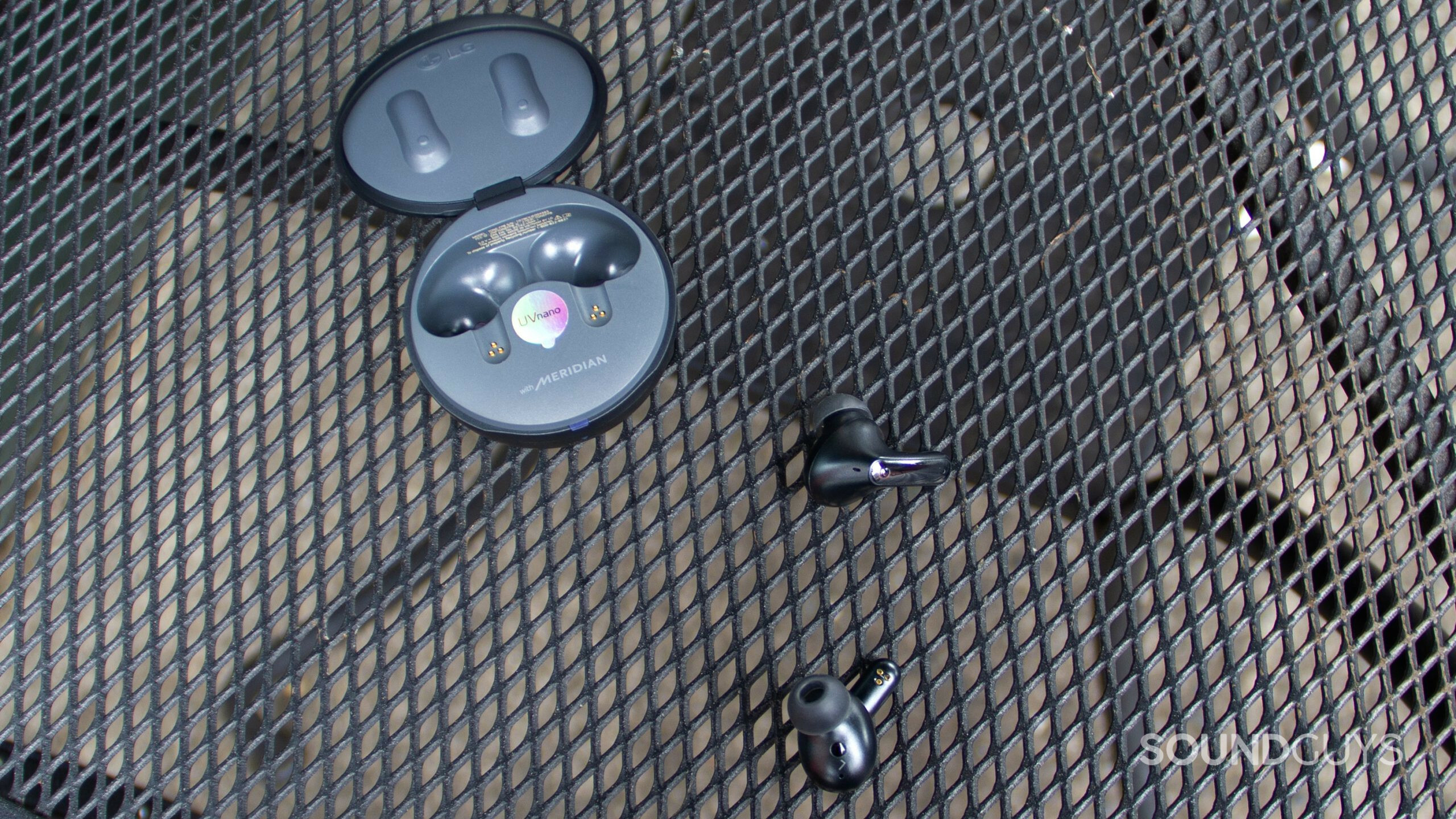 On a metal table the open case of the LG TONE Free FP8 with the earbuds out.