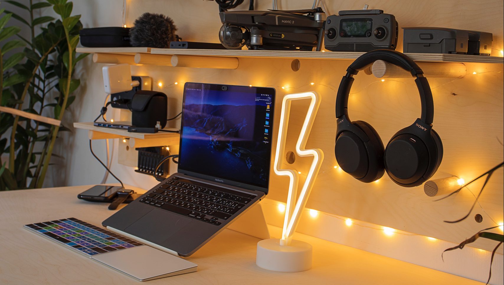 A desk with laptop, headphones, and other Bluetooth peripherals