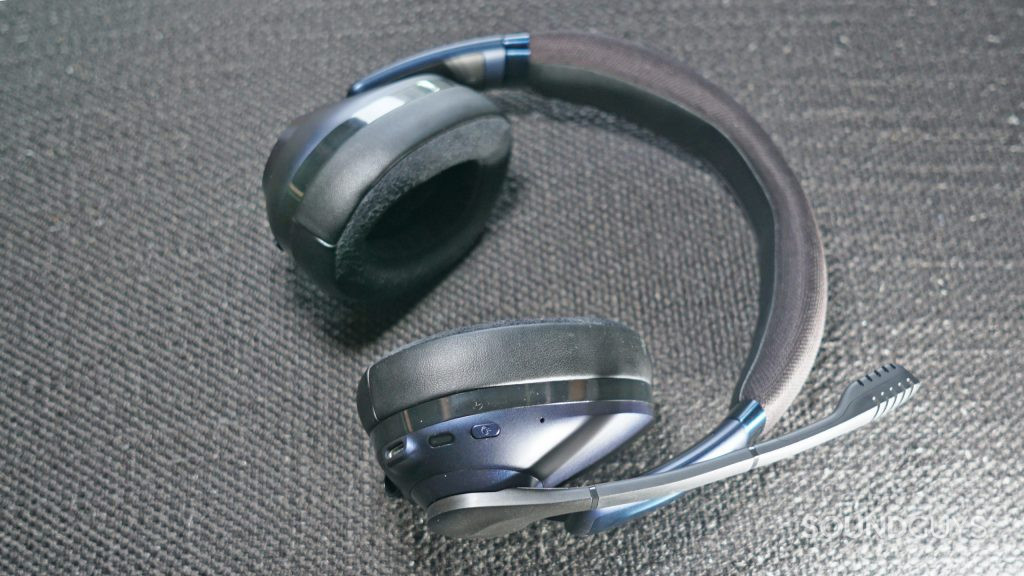 The EPOS H3PRO Hybrid lays on a fabric surface.