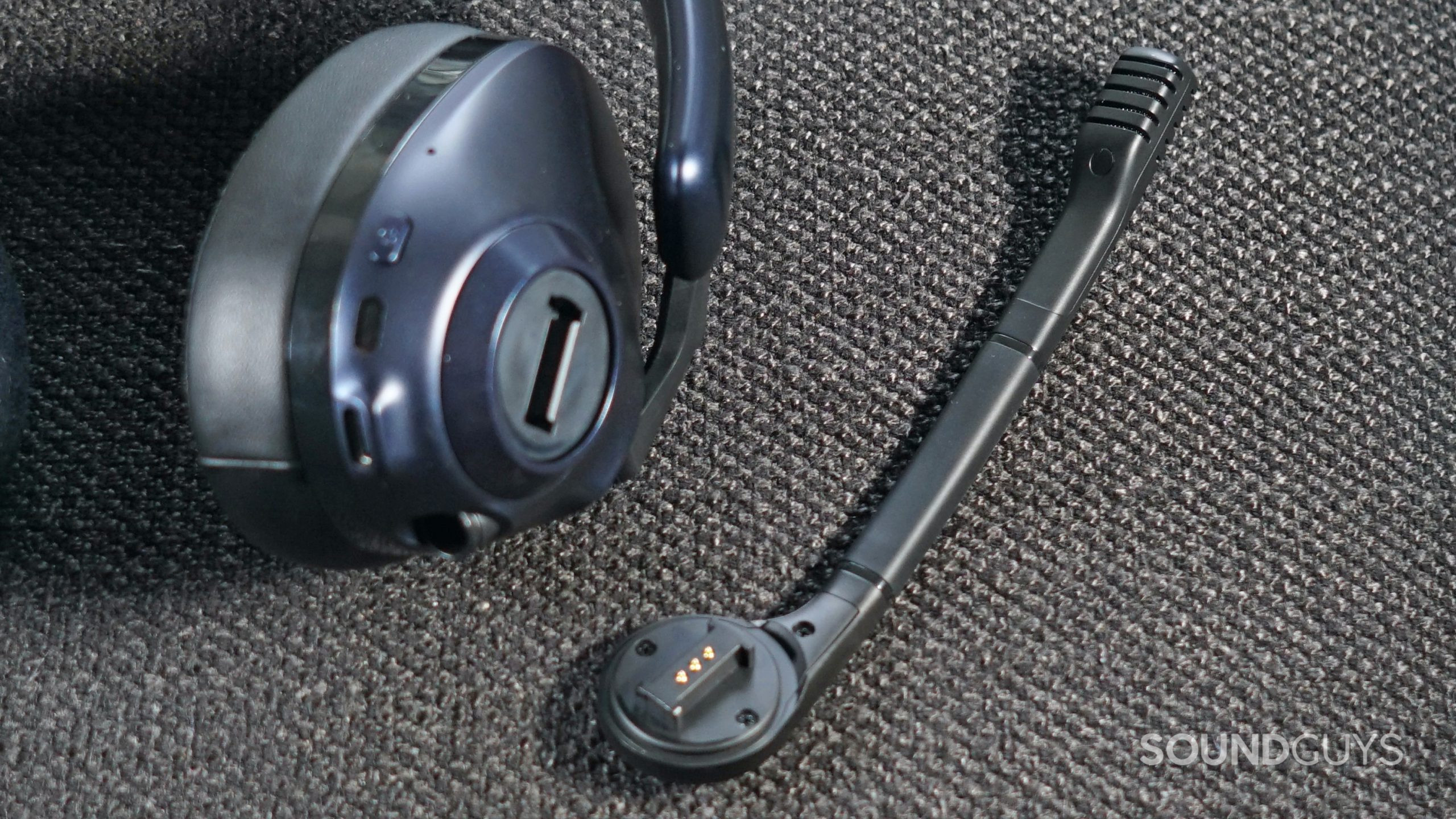 EPOS-H3PRO-Hybrid-detached-mic The EPOS H3PRO Hybrid gaming headset lays on a fabric surface with its microphone detached.