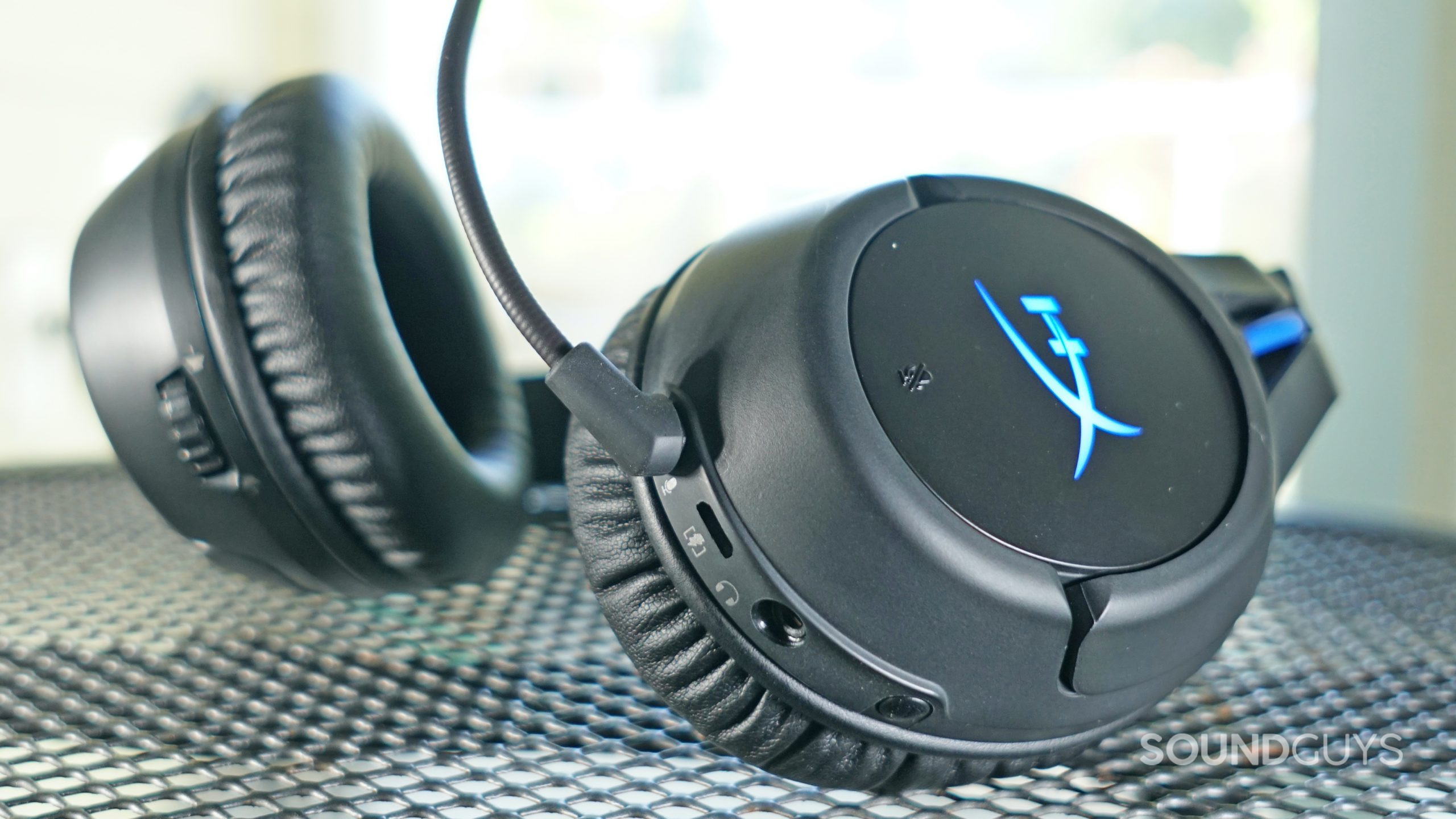 The HyperX Cloud Flight Wireless lays on a metal table in front of a window.