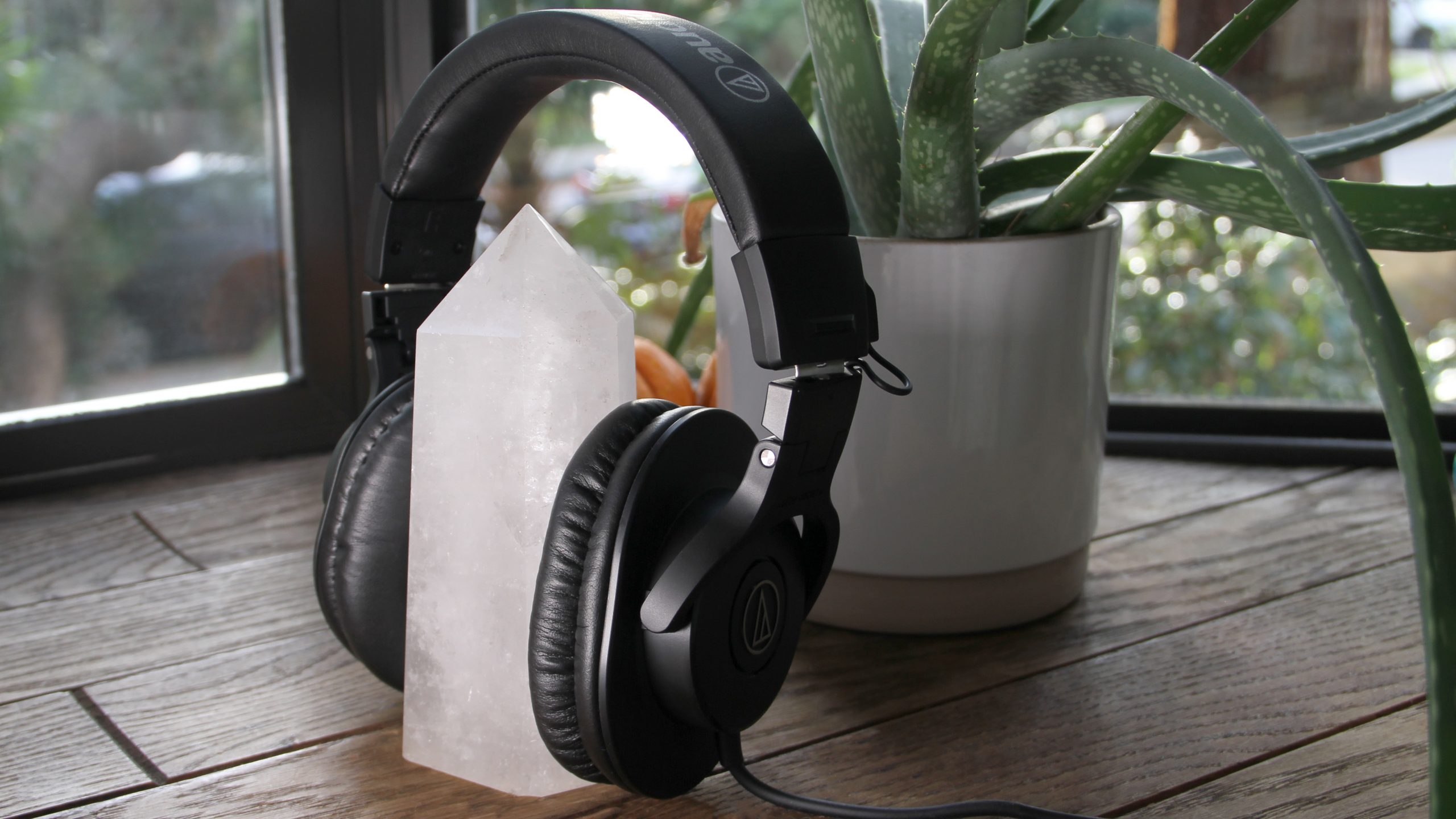 The Audio-Technica ATH-M30x set around a large crystal with a plant in the background.