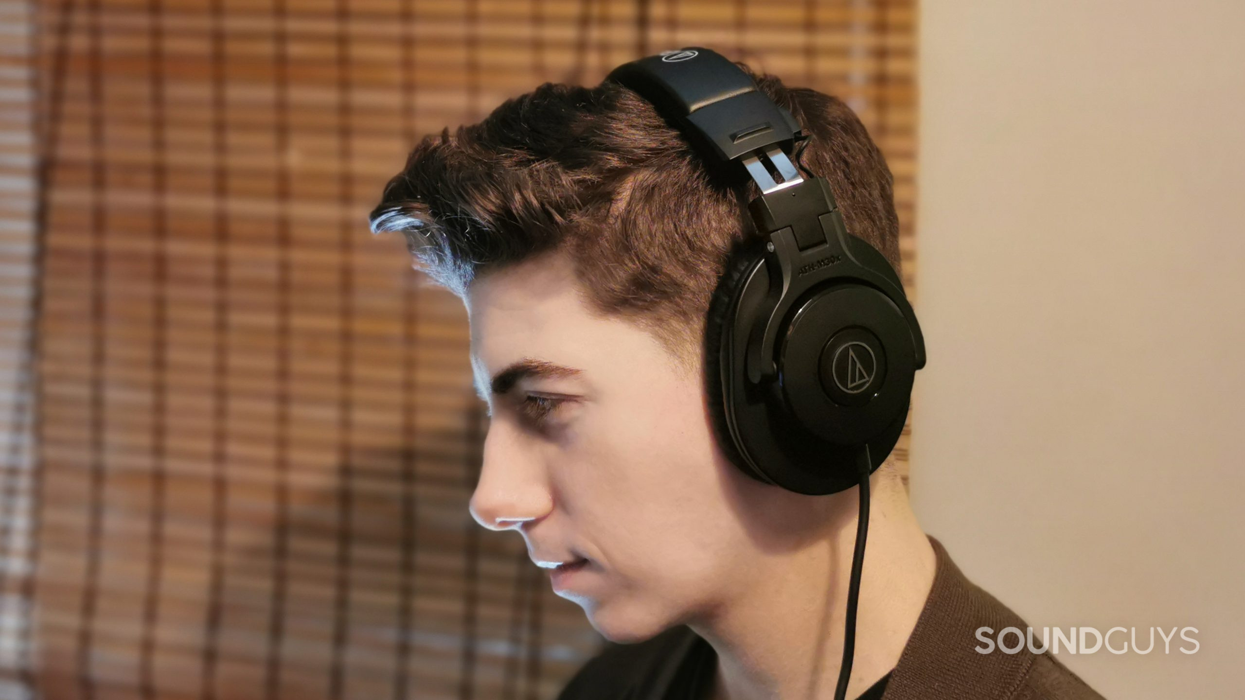 A man faces left wearing the Audio-Technica ATH-M30x.