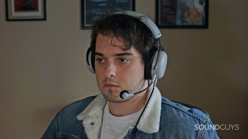 A man sits a computer wearing the Beyerdynamic MMX150 gaming headset.