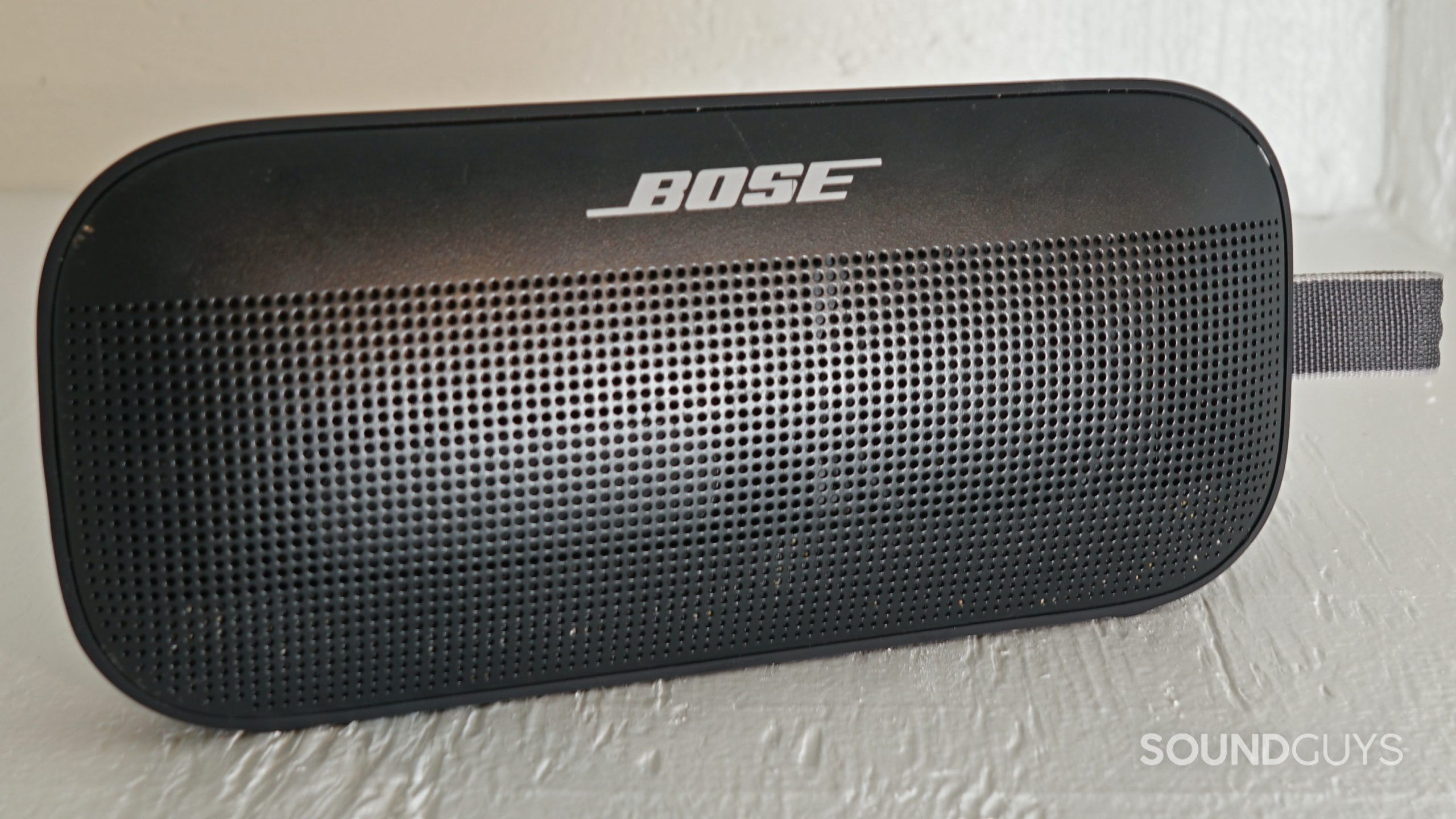 The Bose SoundLink Flex in black on top of a gray surface.