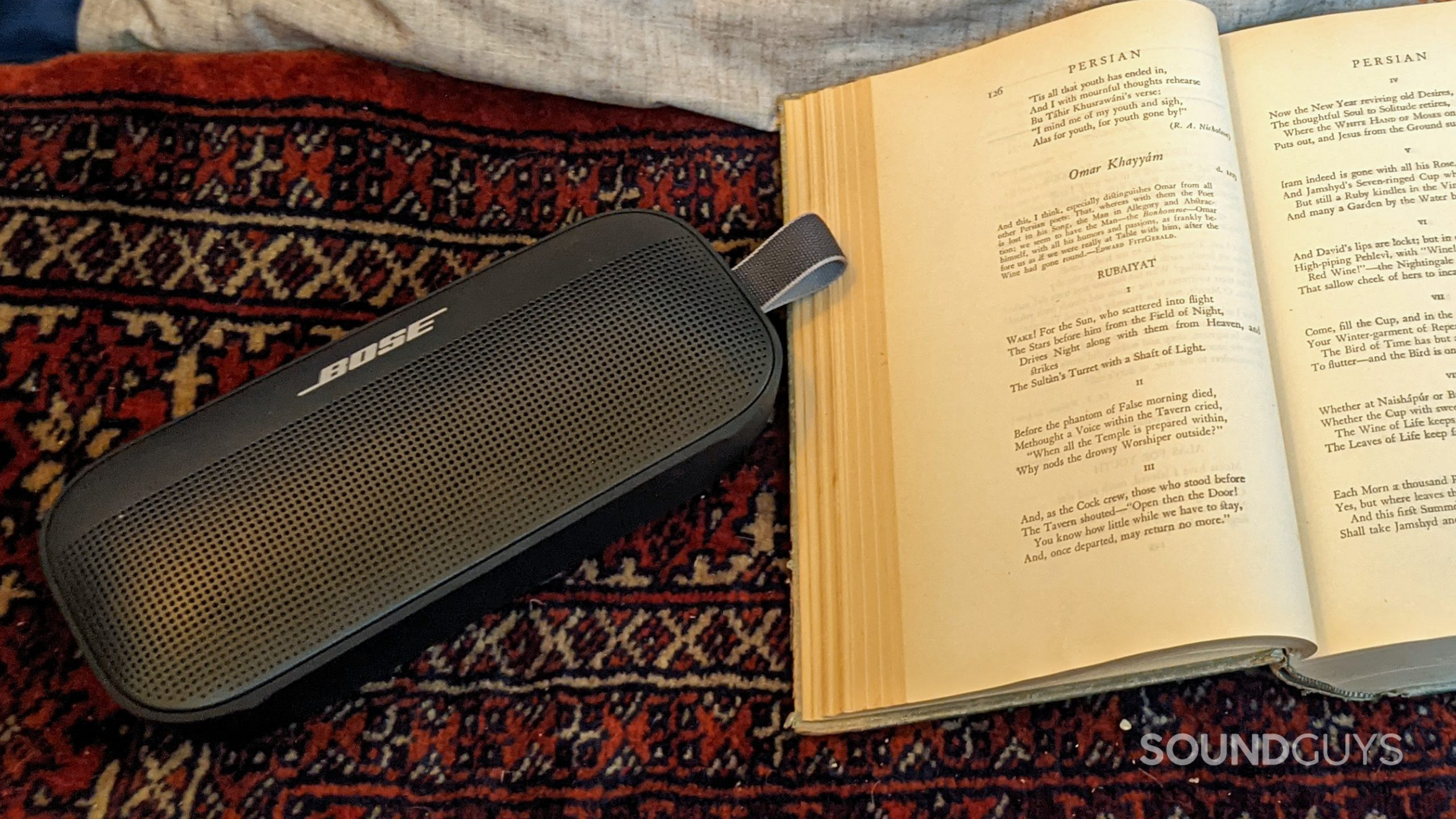 The Bose SoundLink Flex next to an open book.
