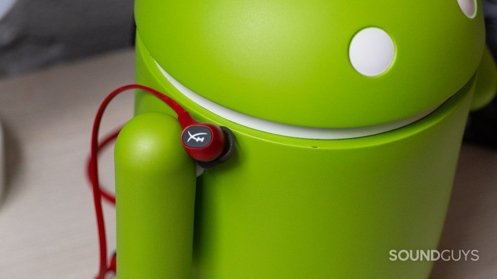 HyperX Cloud Buds resting on an Android figurine.