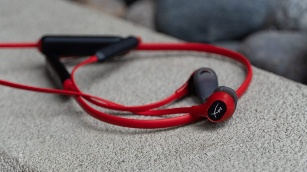 HyperX Cloud Buds Wireless laying on a painted cement ledge.