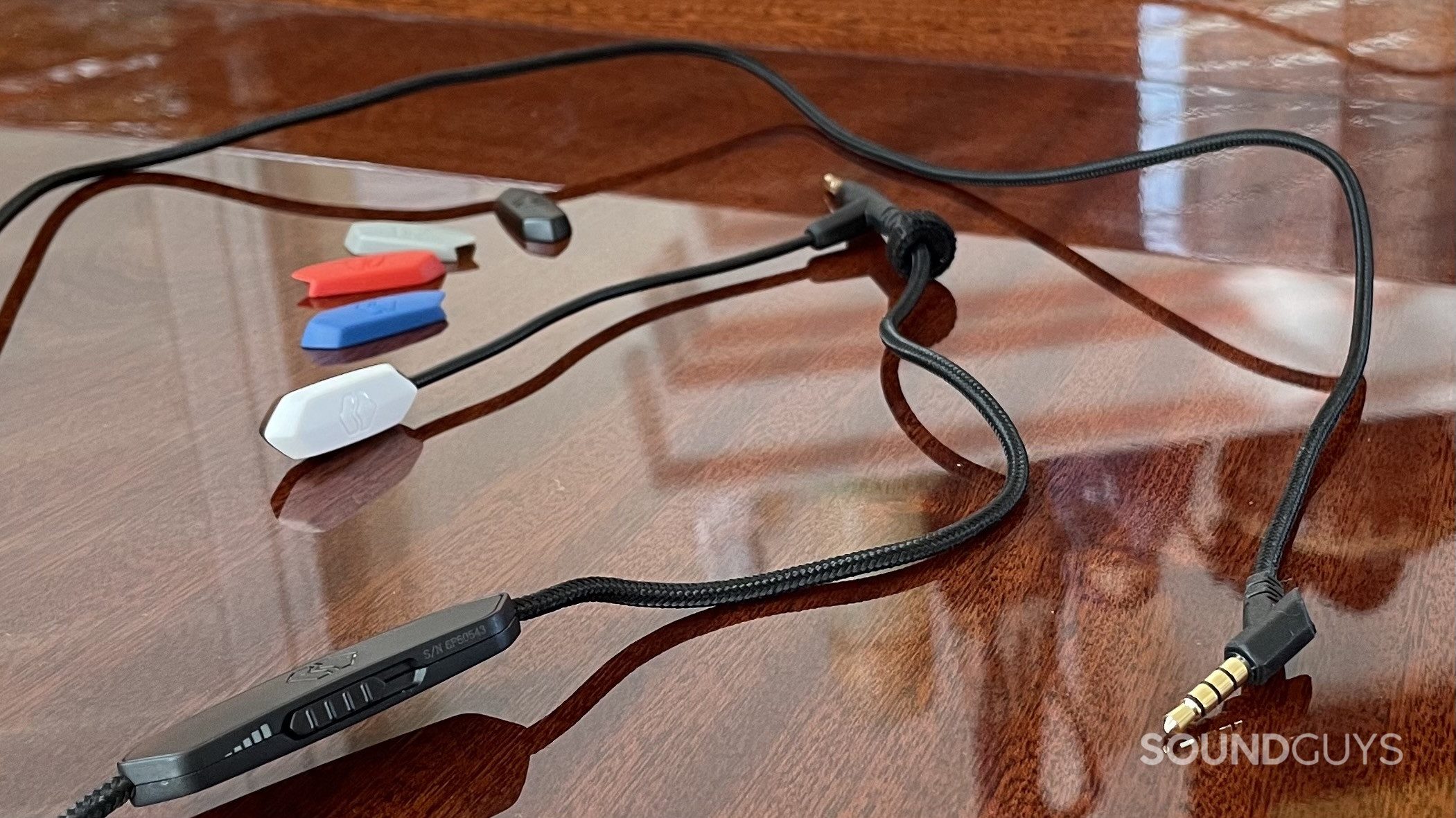 V-Moda BoomPro X mic shield cable module V-MODA BoomPro X and microphone covers resting on a reflective flat surface.
