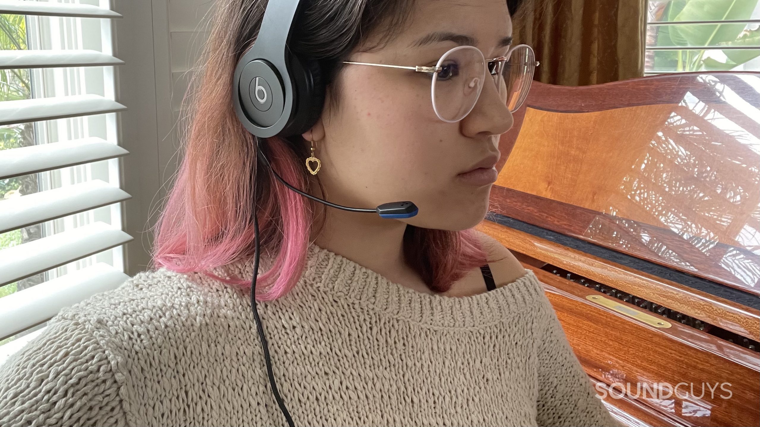 Woman wearing a pair of Beats headphones with the V-MODA BoomPro X plugged in.