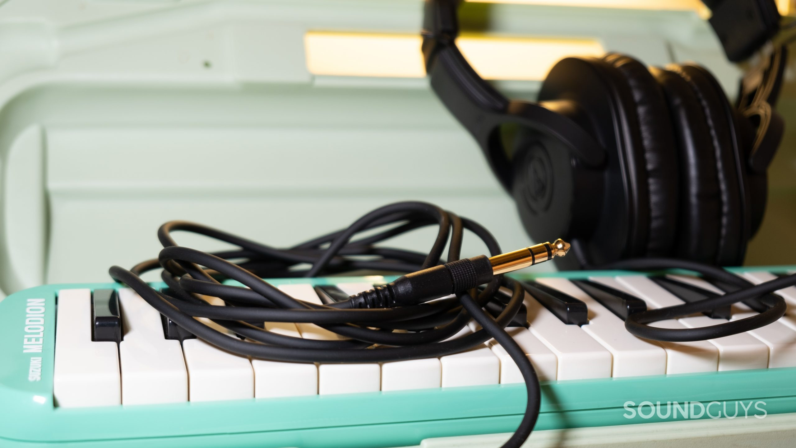 The Audio-Technica ATH-M20x resting with a melodion with the three meter cable in focus.
