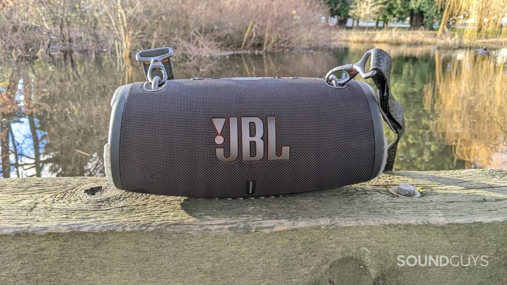 The JBL Xtreme 3 Bluetooth speaker sitting by a pond on a sunny day.