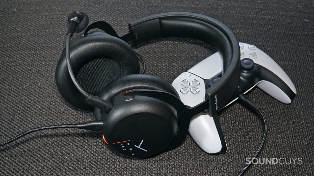 The Beyerdynamic MMX 100 gaming headset lays on a PlayStation DualSense controller.