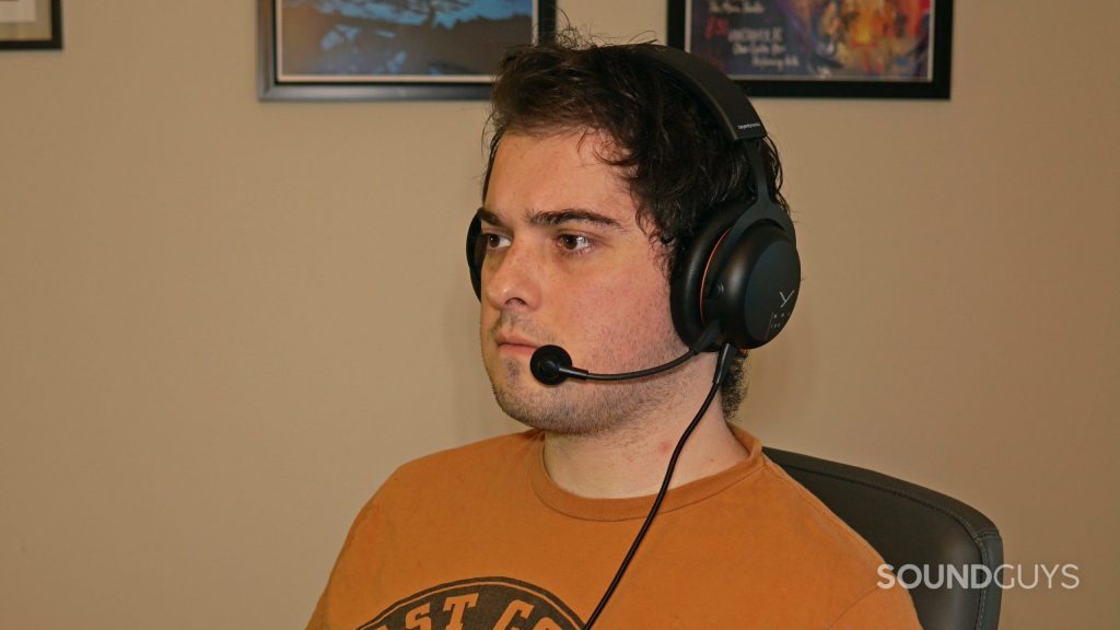 A man sits at a PC wearing the Beyerdynamic MMX 100 gaming headset.