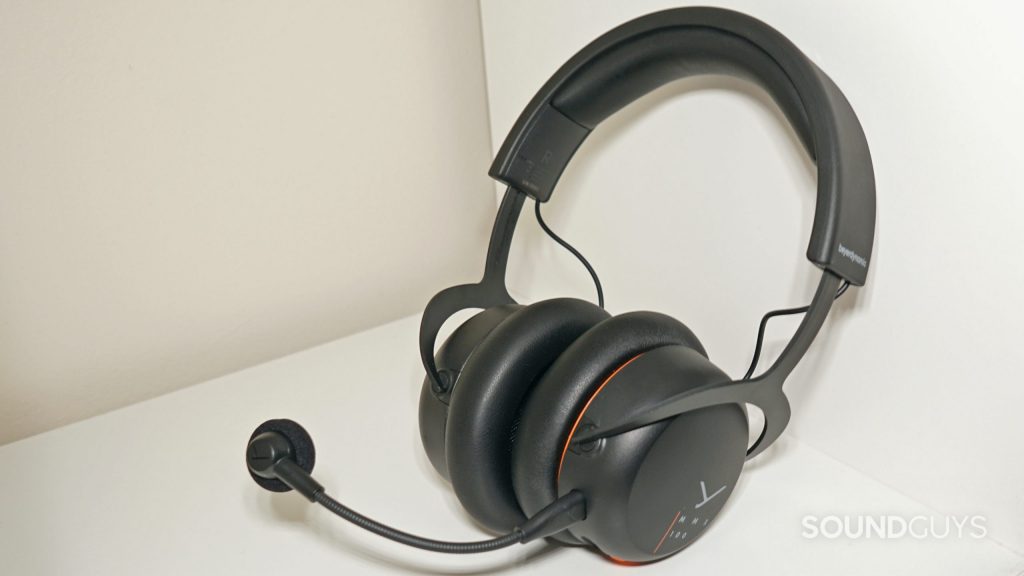 The Beyerdynamic MMX 100 gaming headset leans on the side of a white wooden shelf.