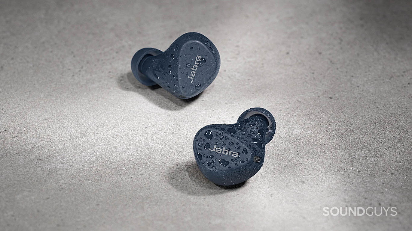 The Jabra Elite 4 Active buds have some water droplets on them.