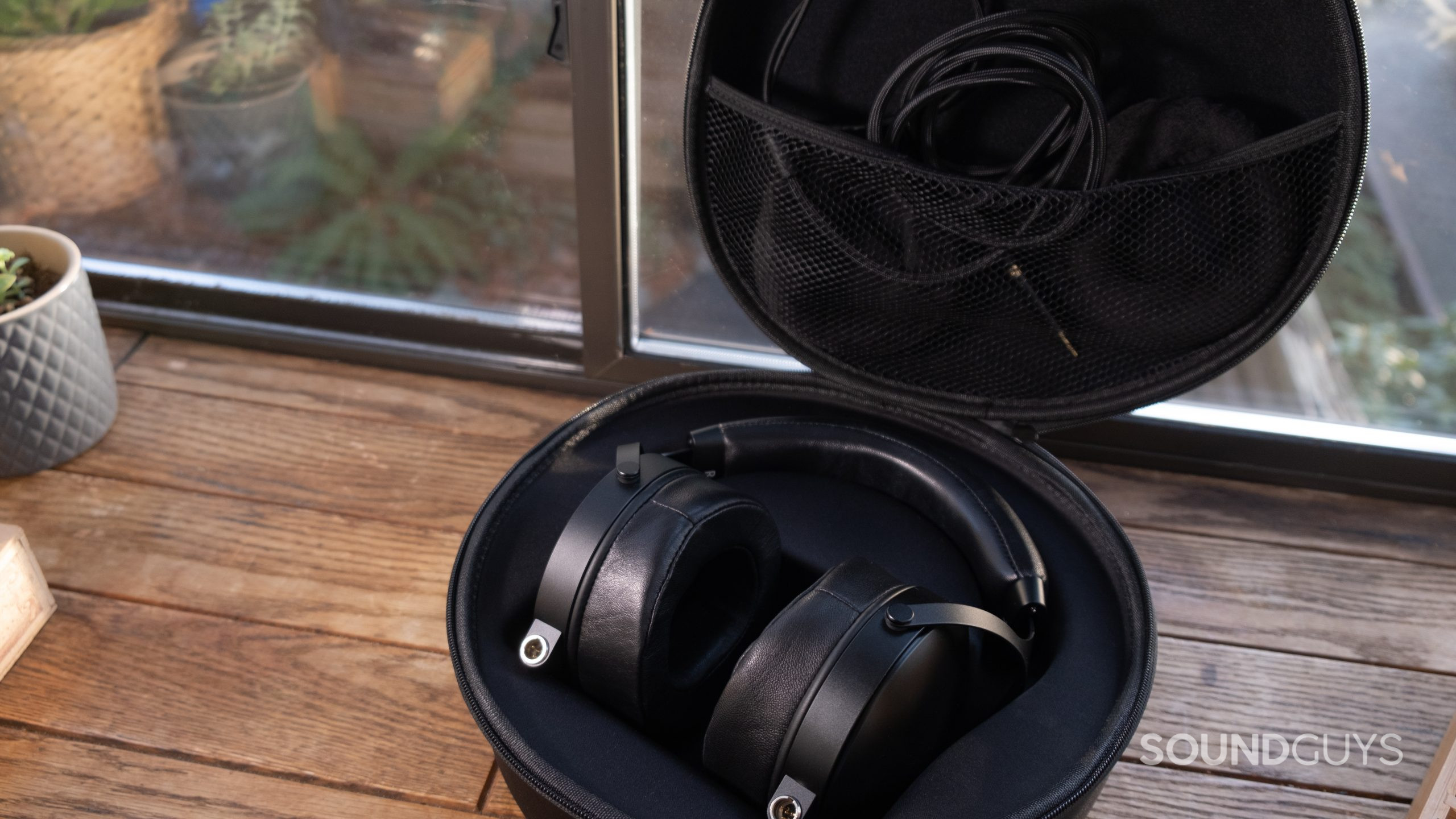 The Monolith by Monoprice M1570C rests in the molded case with the lid open showing the accessories in the inner pocket.