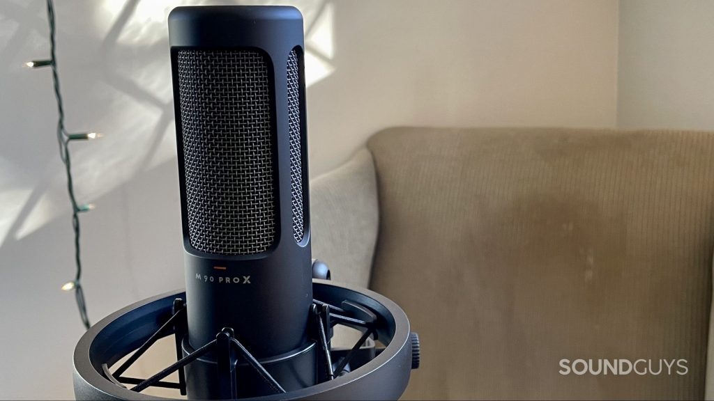 Beyerdynamic M90 PRO X with an armchair and string lights in the background.