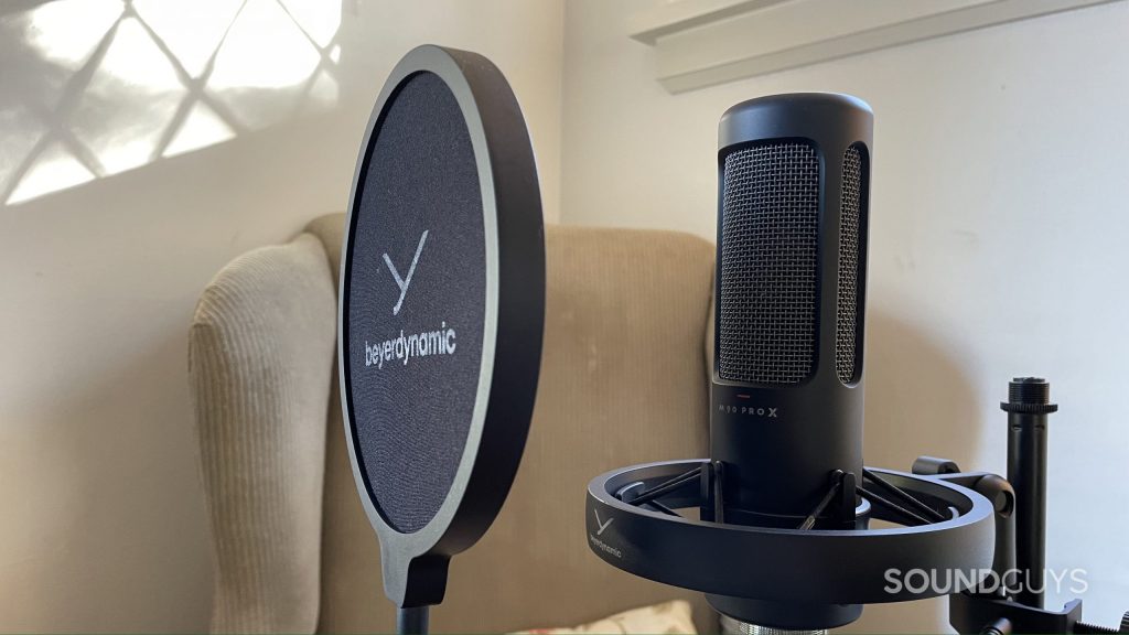 Beyerdynamic M90 PRO X with its pop filter and an armchair in the background.