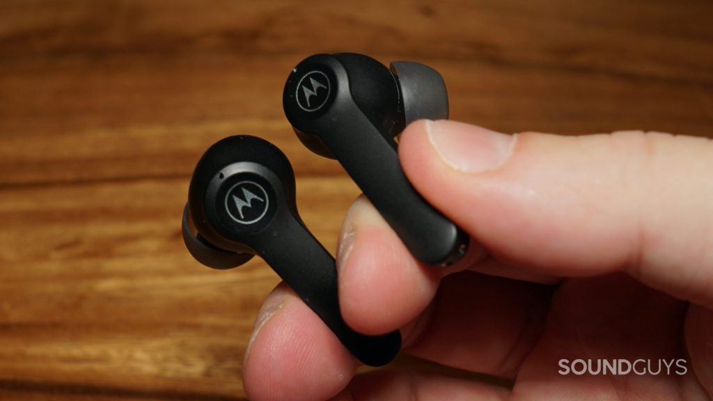 A hand holds the Motorola Moto Buds S ANC