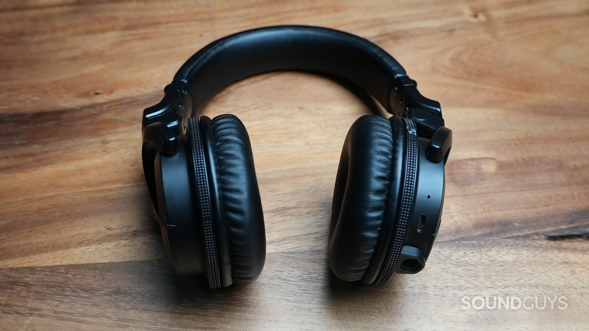 The Pioneer HDJ-CUE1BT lying on t able with its earcups oriented vertically.