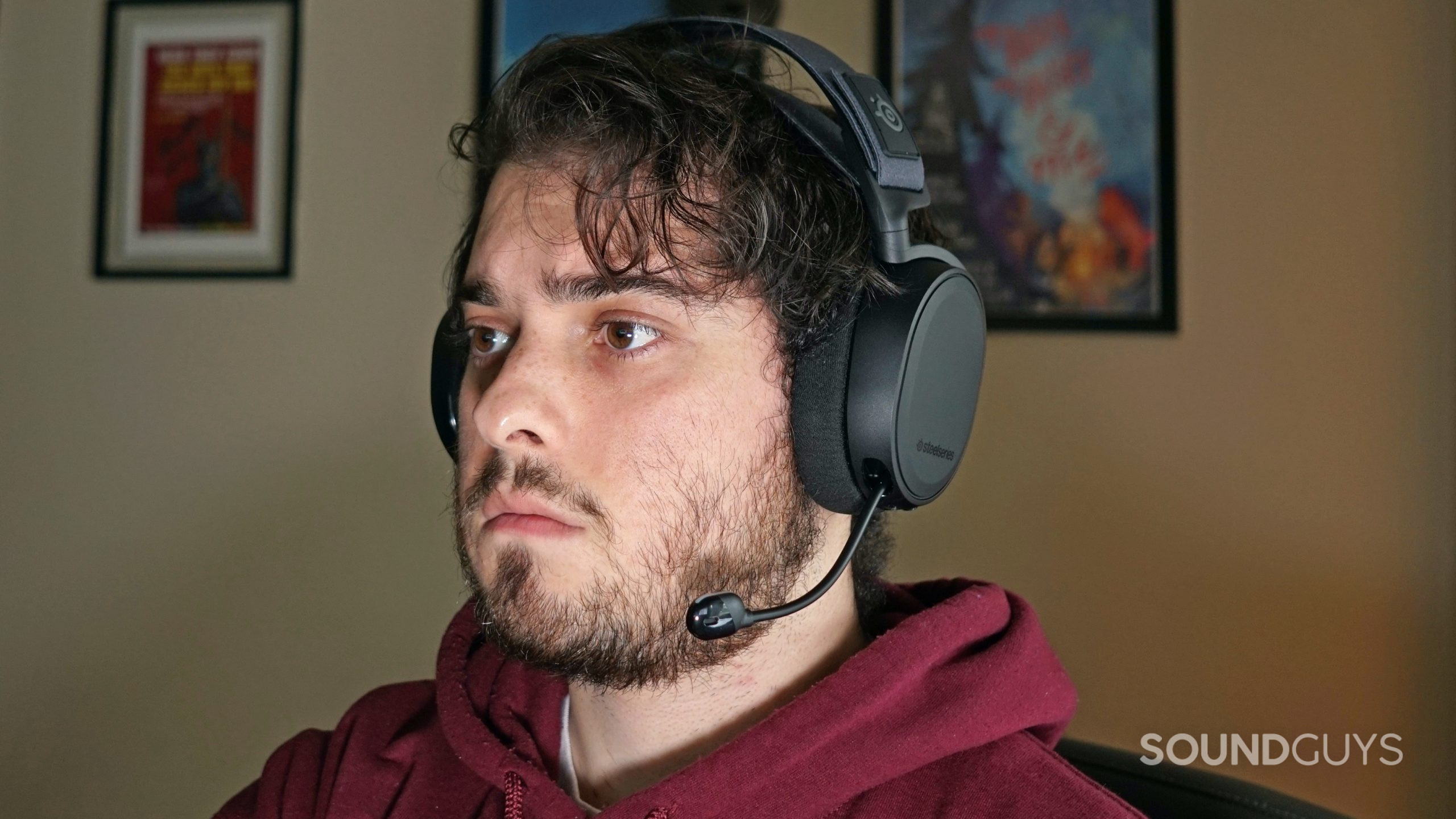 A man sits at a computer wearing the SteelSeries Arctis 7+ gaming headset.