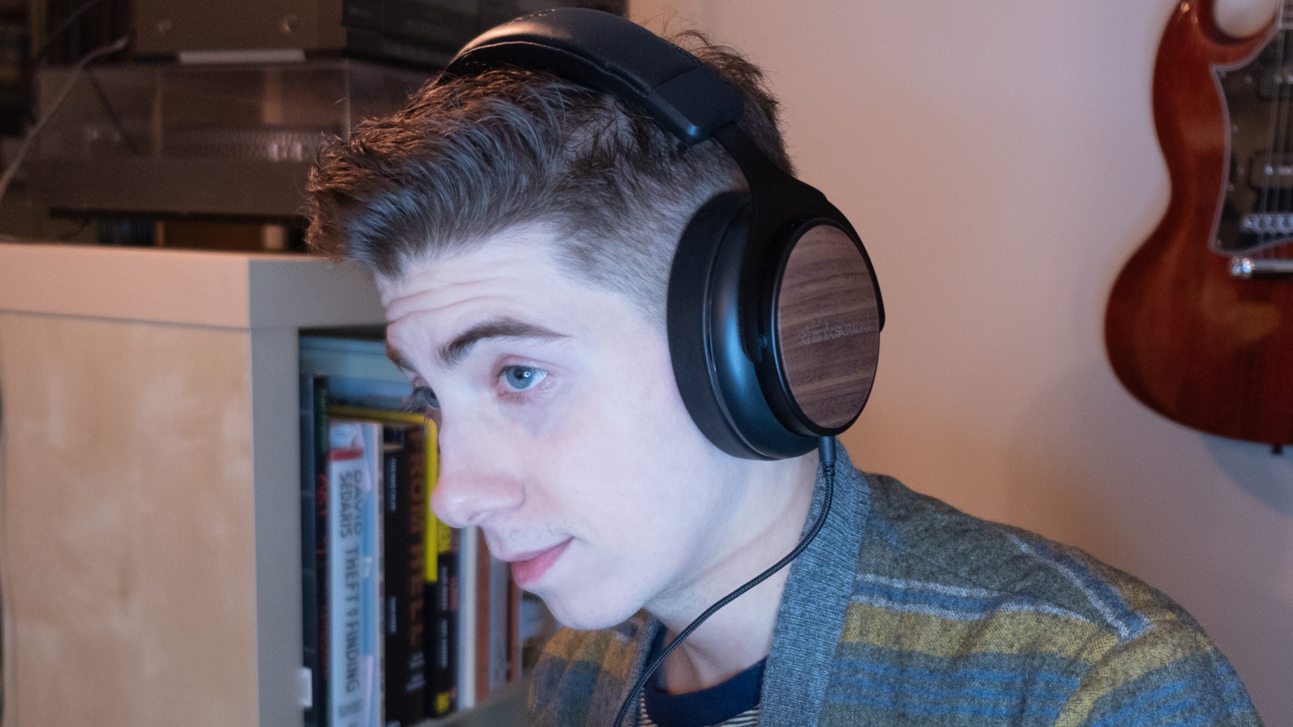 A man looks left while wearing the Thinksound ov21 headphones.