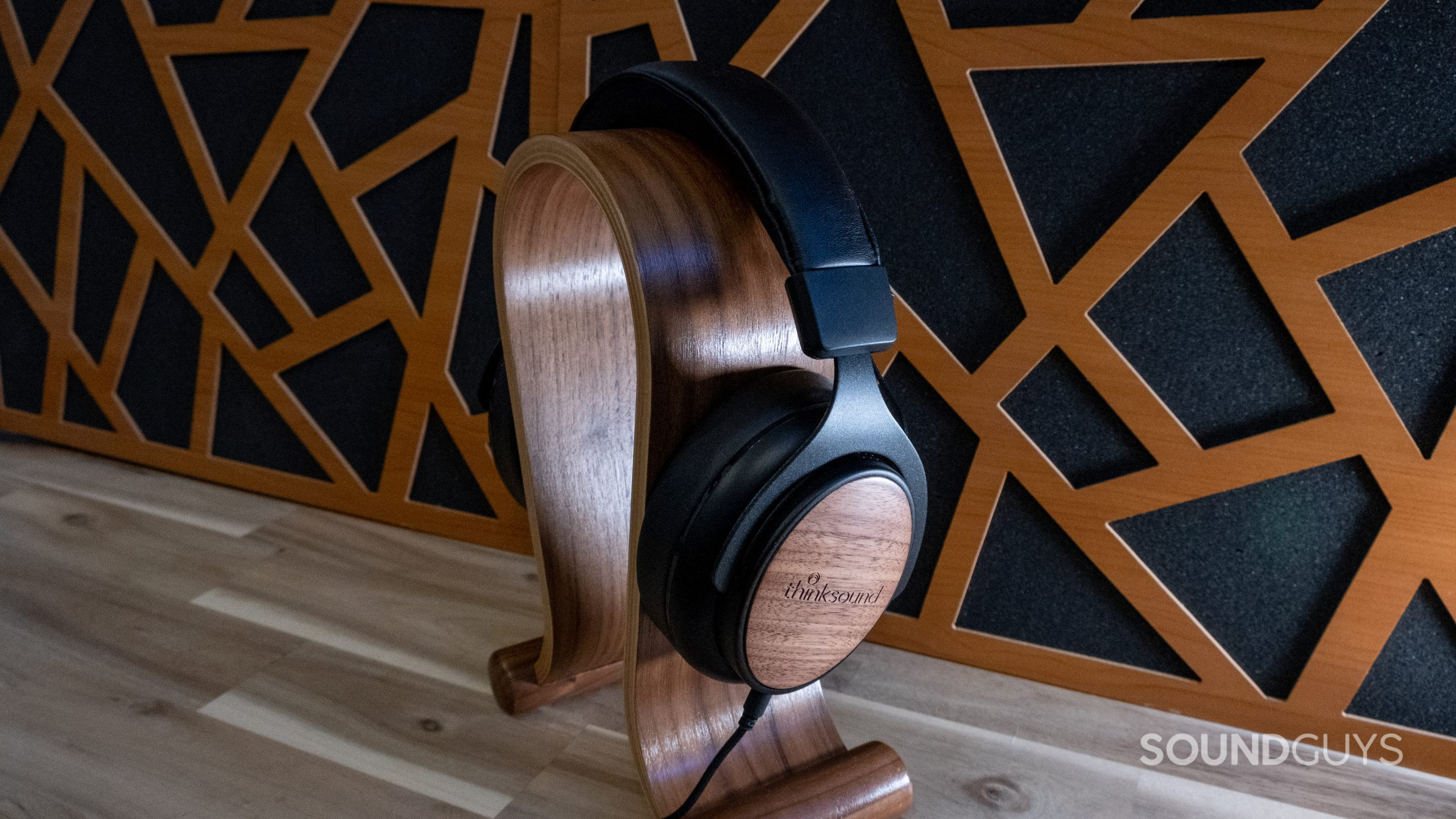 Thinksound ov21 centered and fitted over a wood headphone stand with acoustic panels in the background.