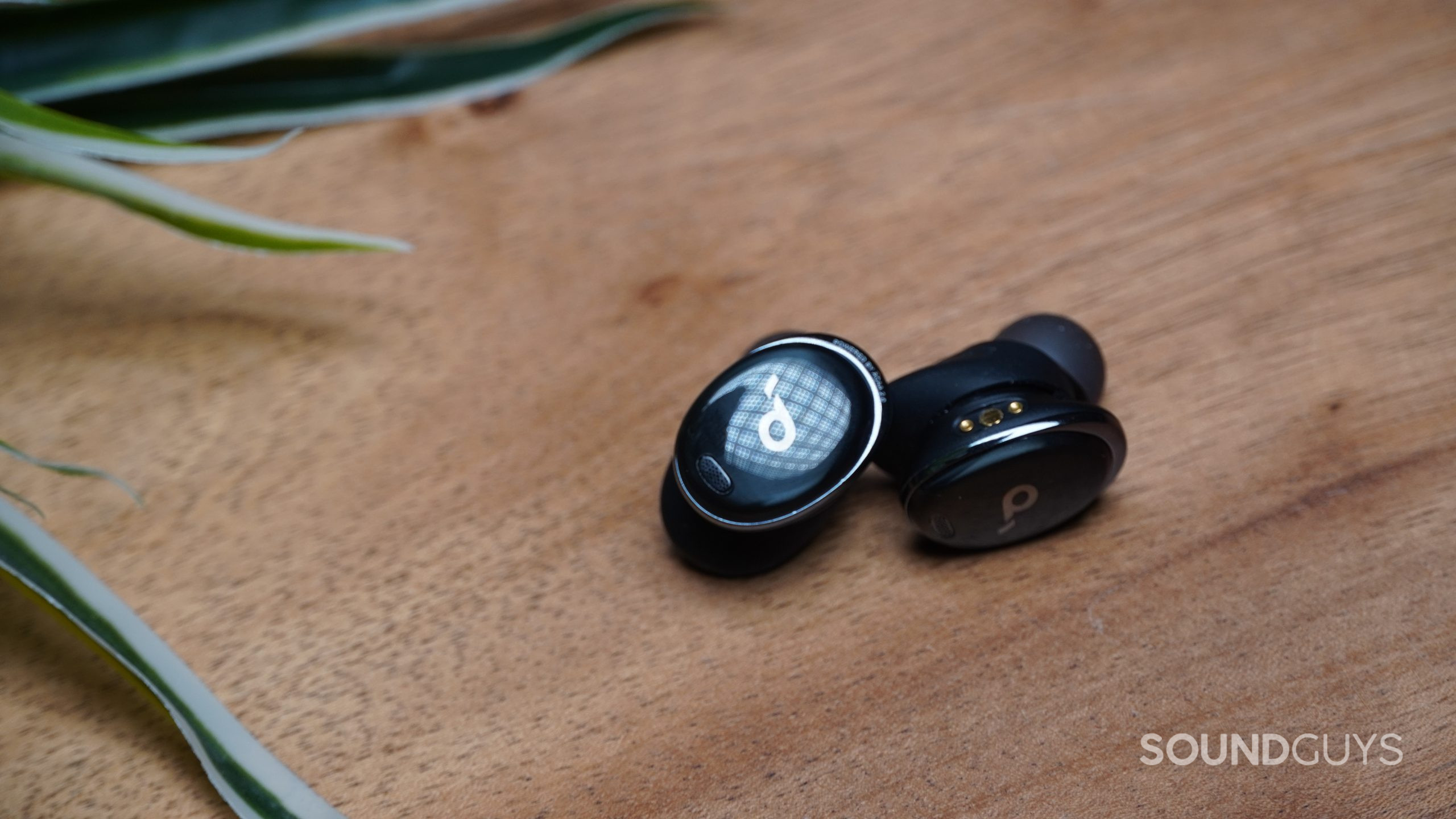 Anker Soundcore Liberty 3 Pro earbuds resting on a wood surface.