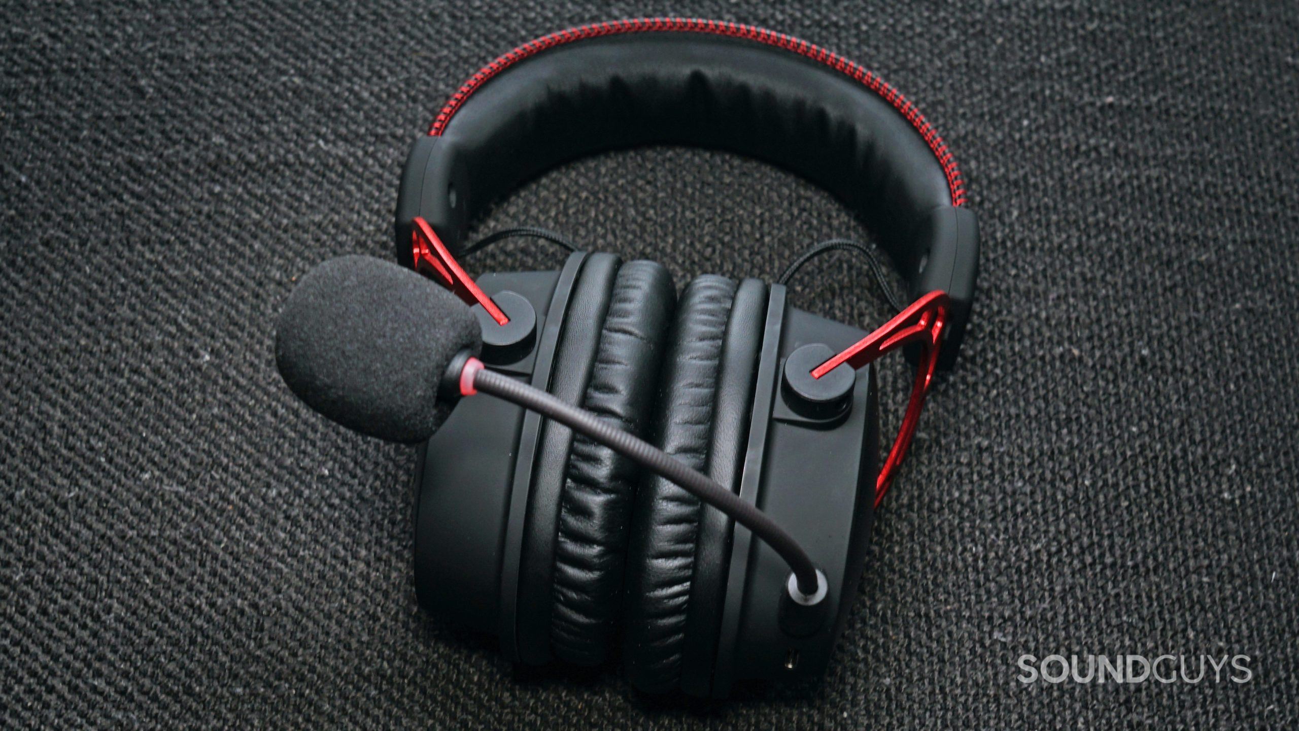 The HyperX Cloud Alpha Wireless gaming headset lays on a fabric surface
