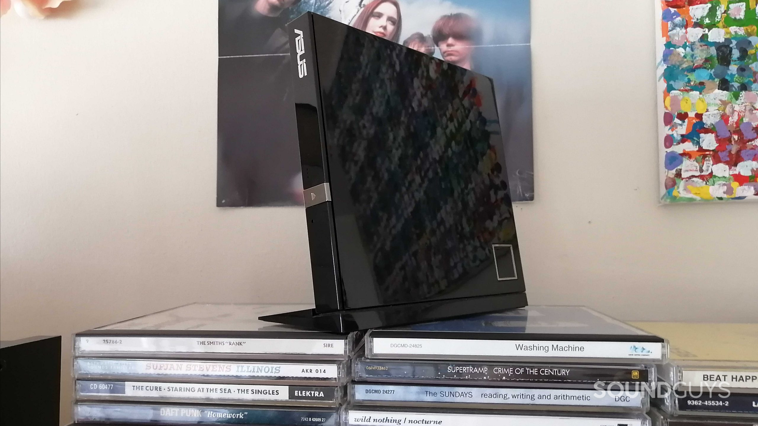 An external Blu-ray/DVD/CD drive on top of several CDs.