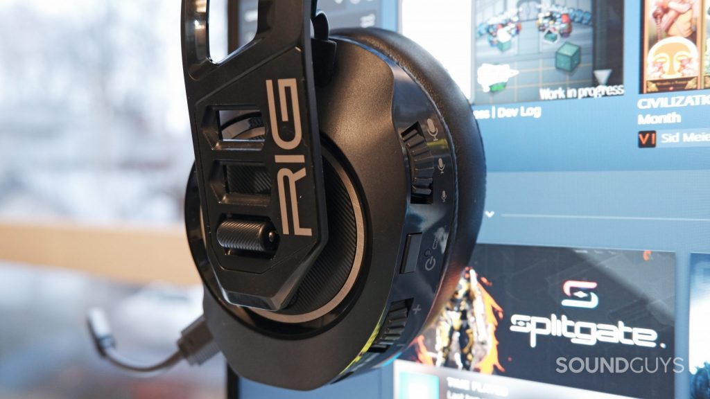 The RIG 700 PRO HS resting on a computer monitor with a Steam library open.