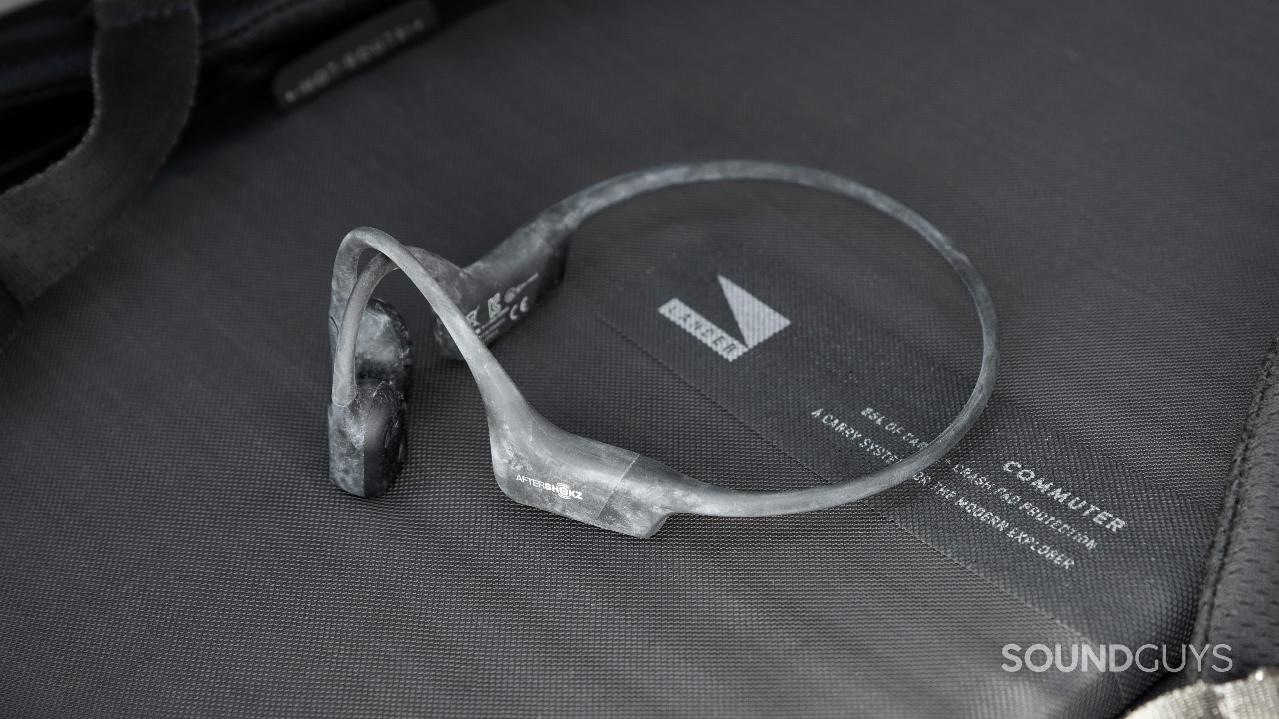 The Aftershokz Aeropex is covered in chalk while resting on a black surface.
