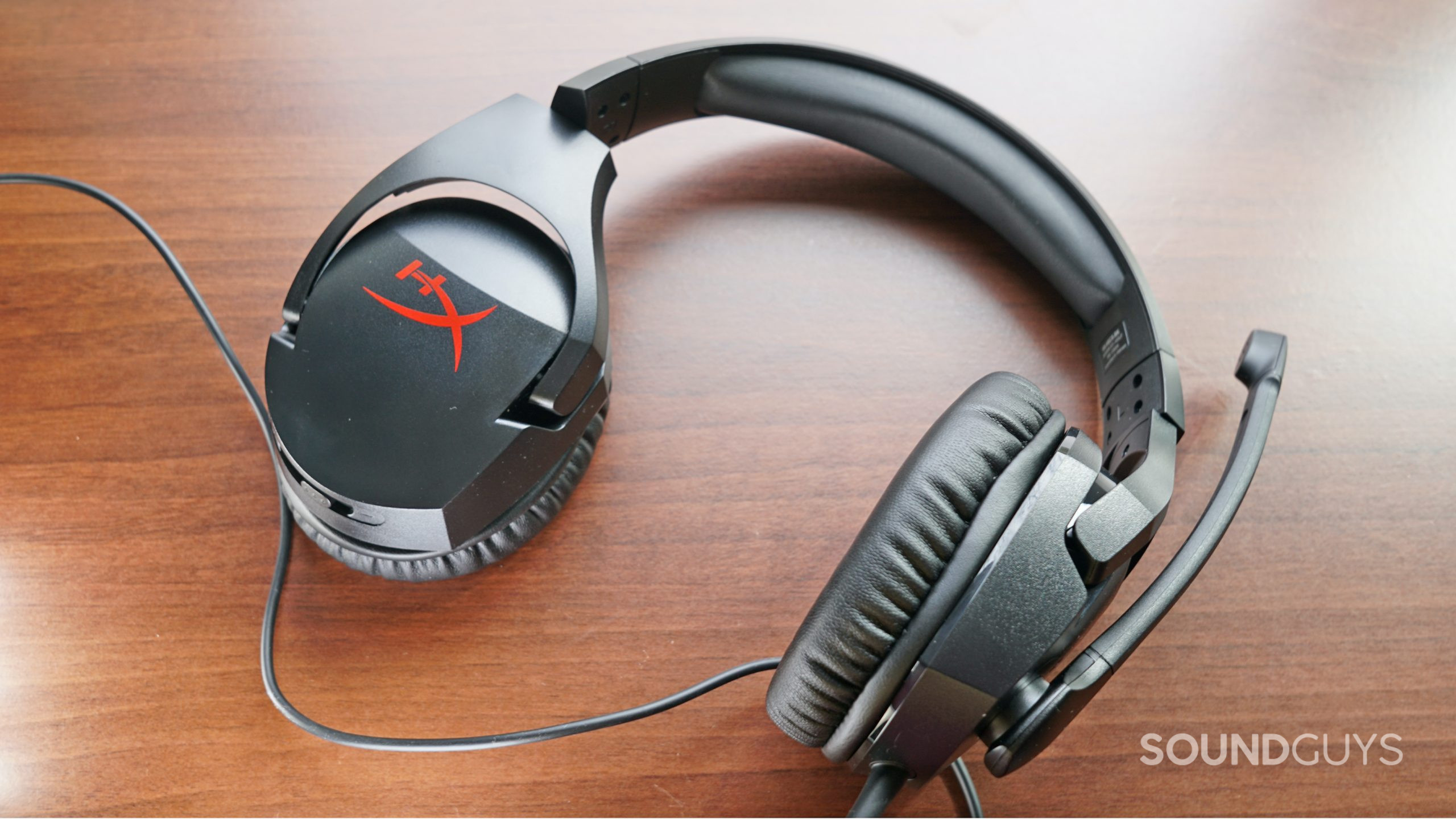 The HyperX Cloud Stinger gaming headset lays on a wooden surface.