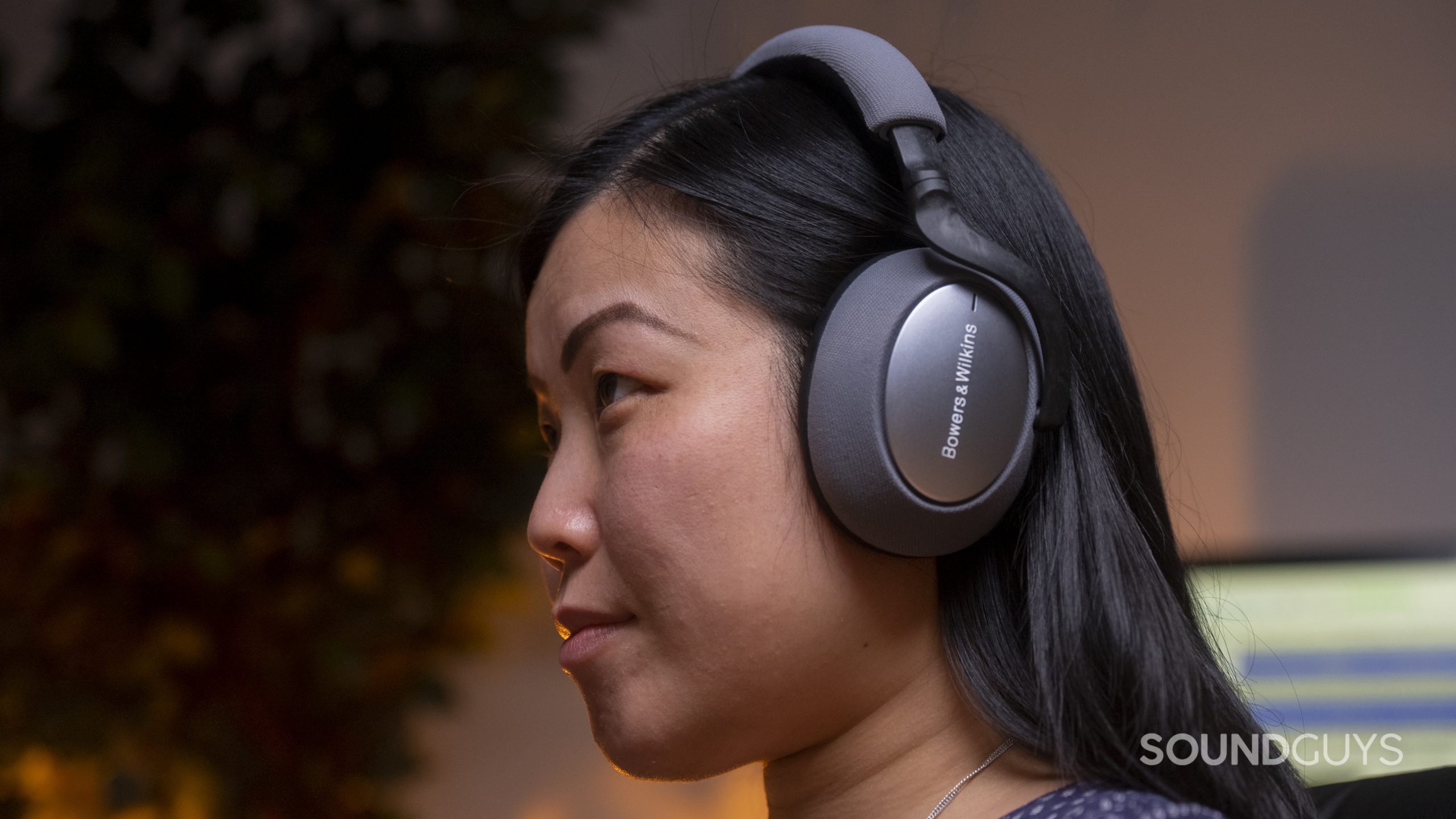 A woman wearing the Bowers &amp; Wilkins PX7.