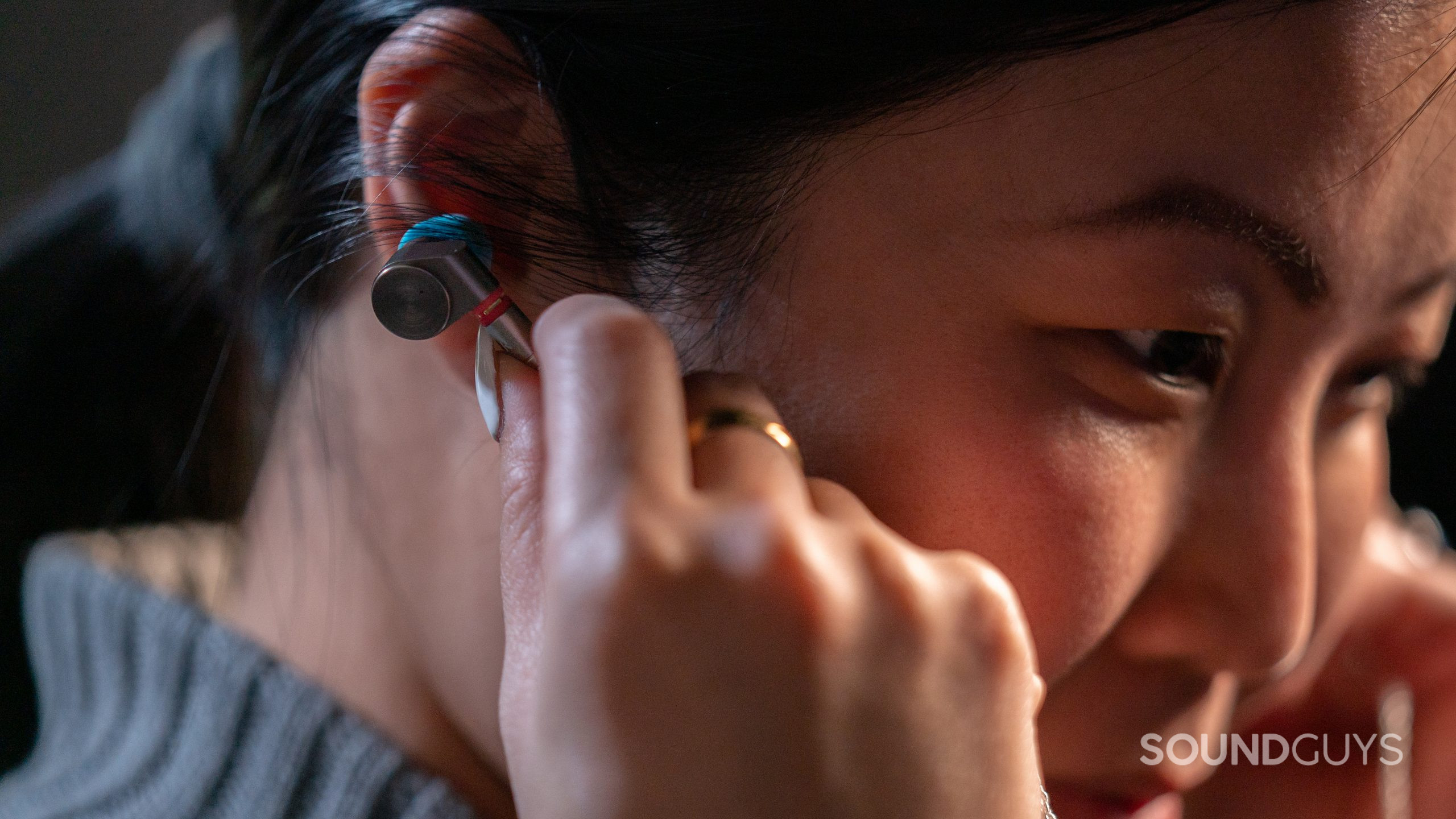 A woman faces left while holding the Linsoul TIN Audio T2 in her ears.