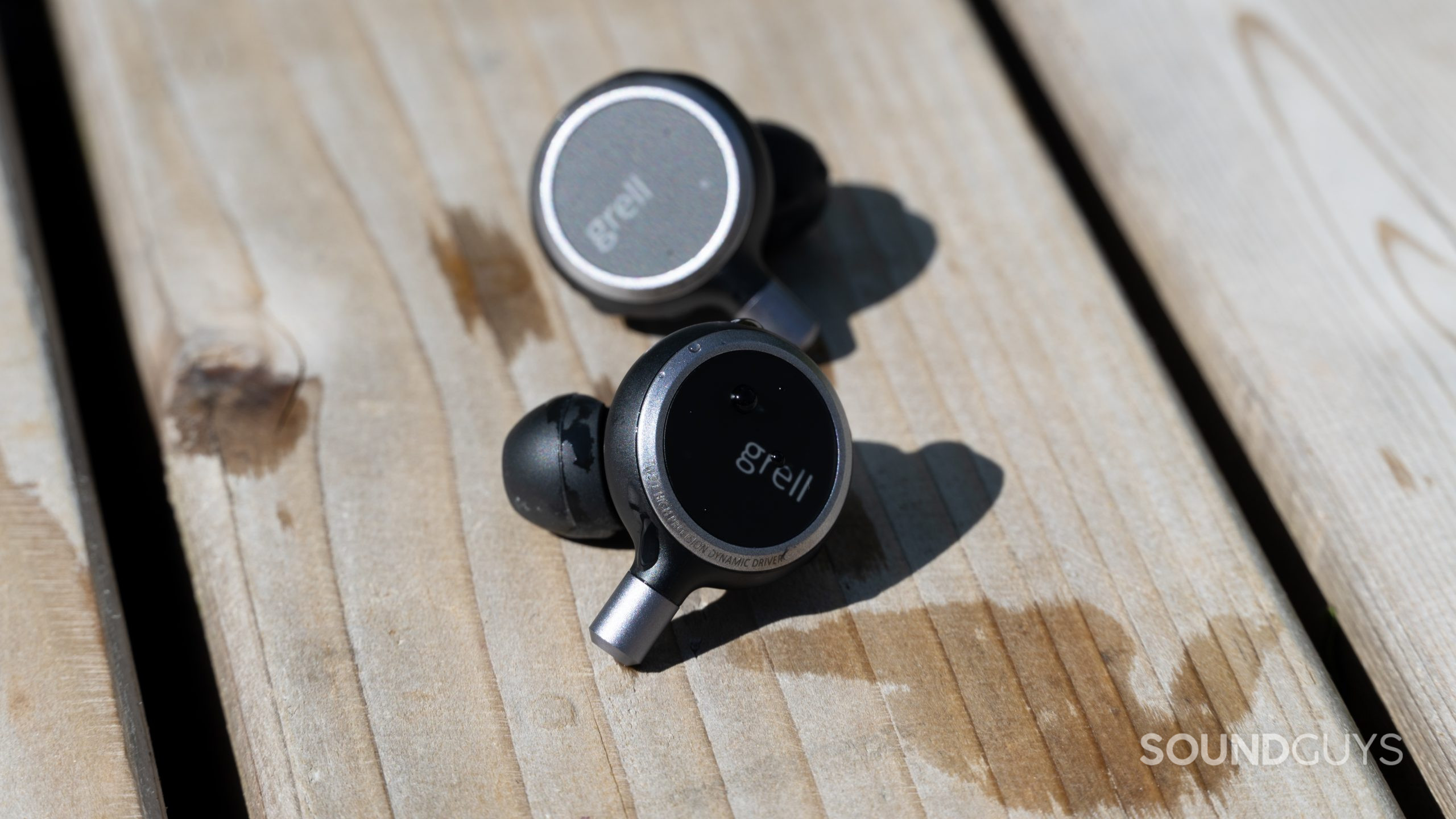 Grell Audio TWS 1 earbuds splashed in water.