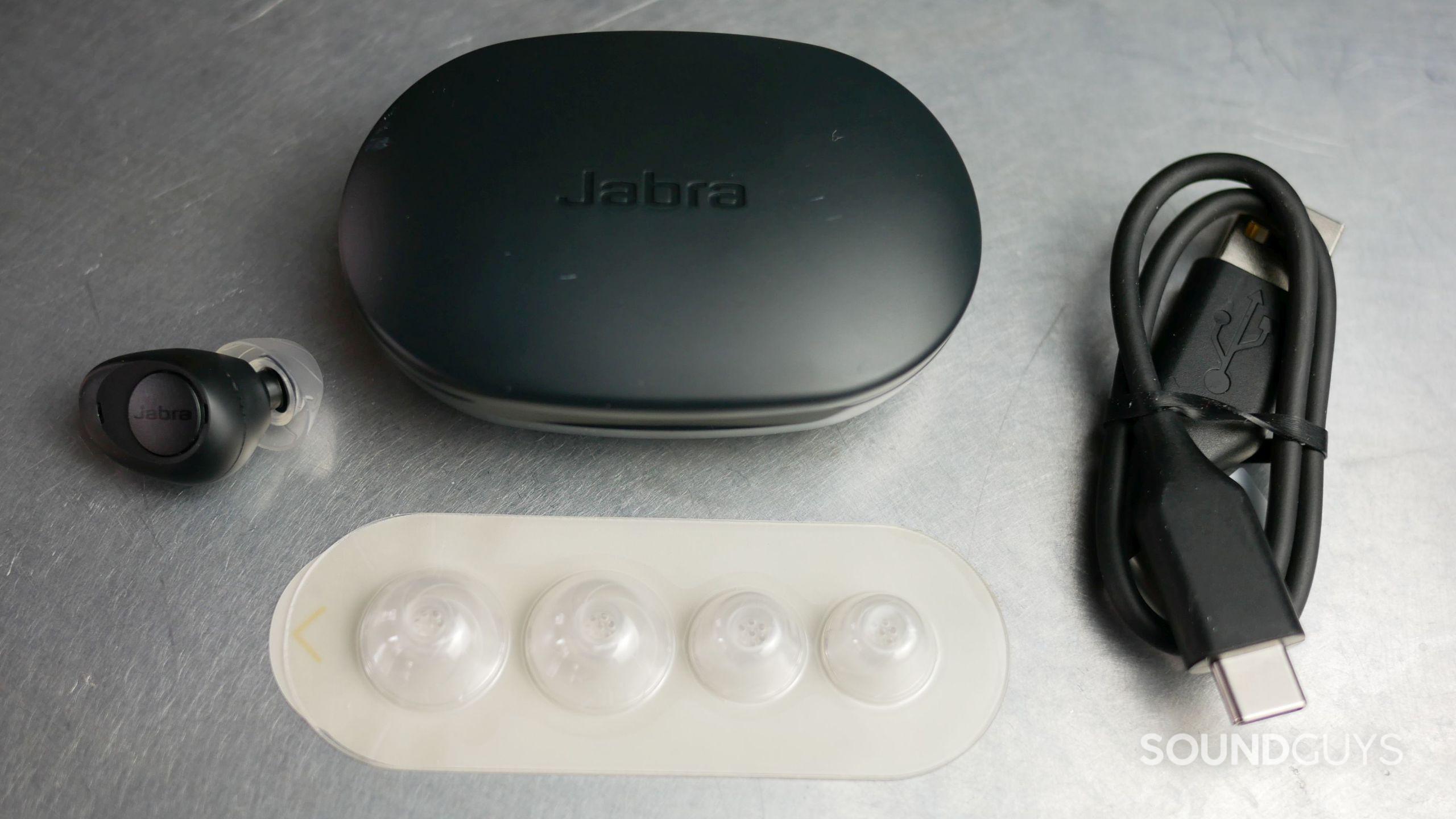 Jabra Enhance Plus accessories, including silicone ear tips, charging case, and charging cable.