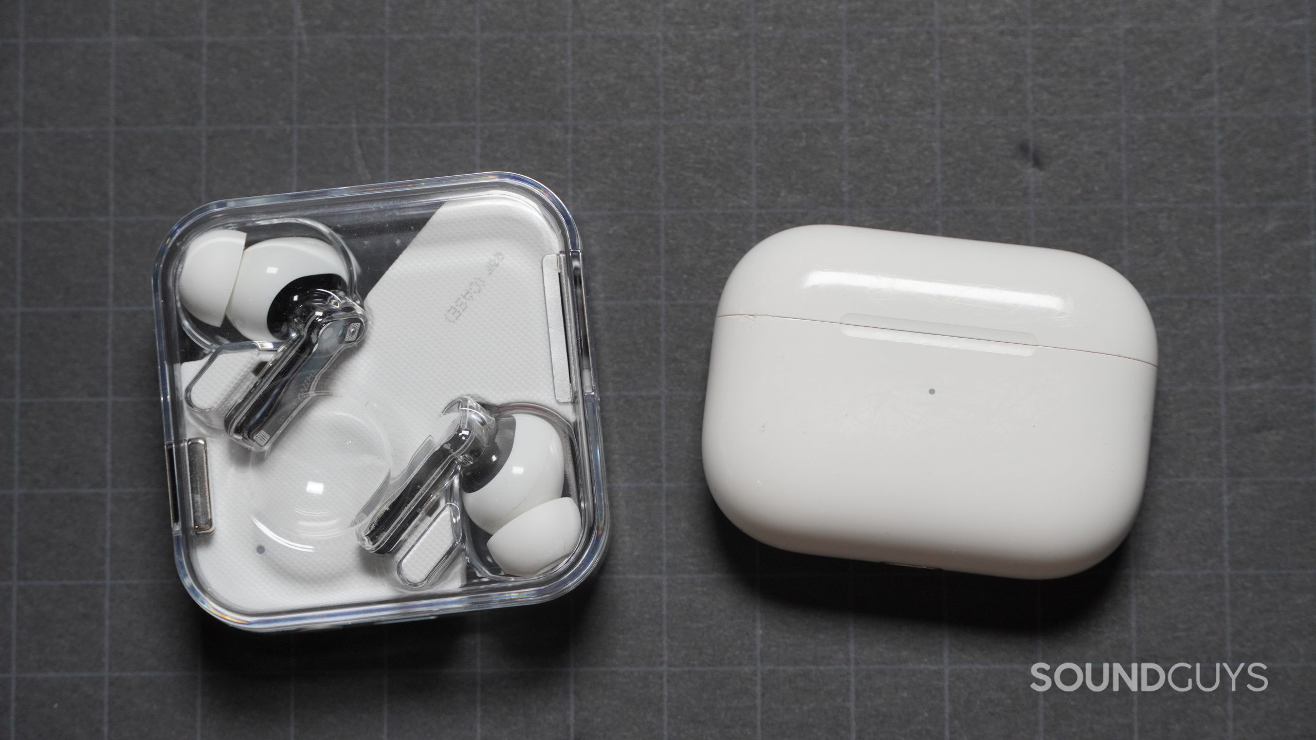 Nothing Ear 1 charging case next to Apple AirPods Pro charging case