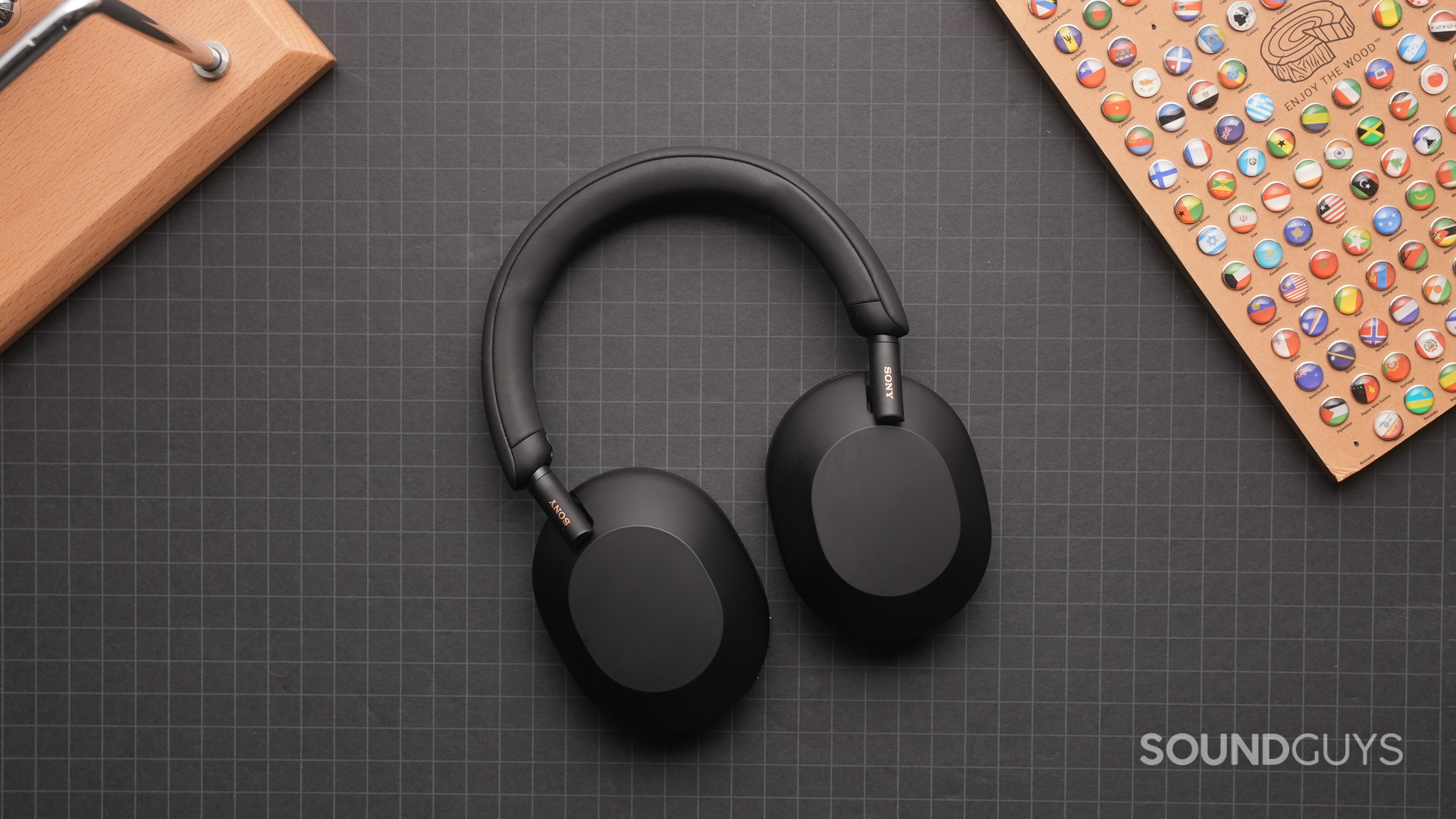The Sony WH-1000XM5 bluetooth headphones lays on a grid sheet.